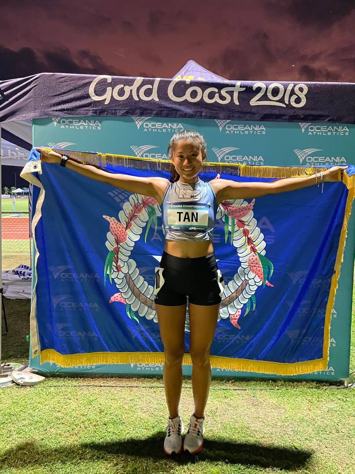 The CNMI’s Tania Tan poses for a photo with the Commonwealth flag at the 2022 Oceania Athletics Championships in Mackay, Australia on Tuesday.