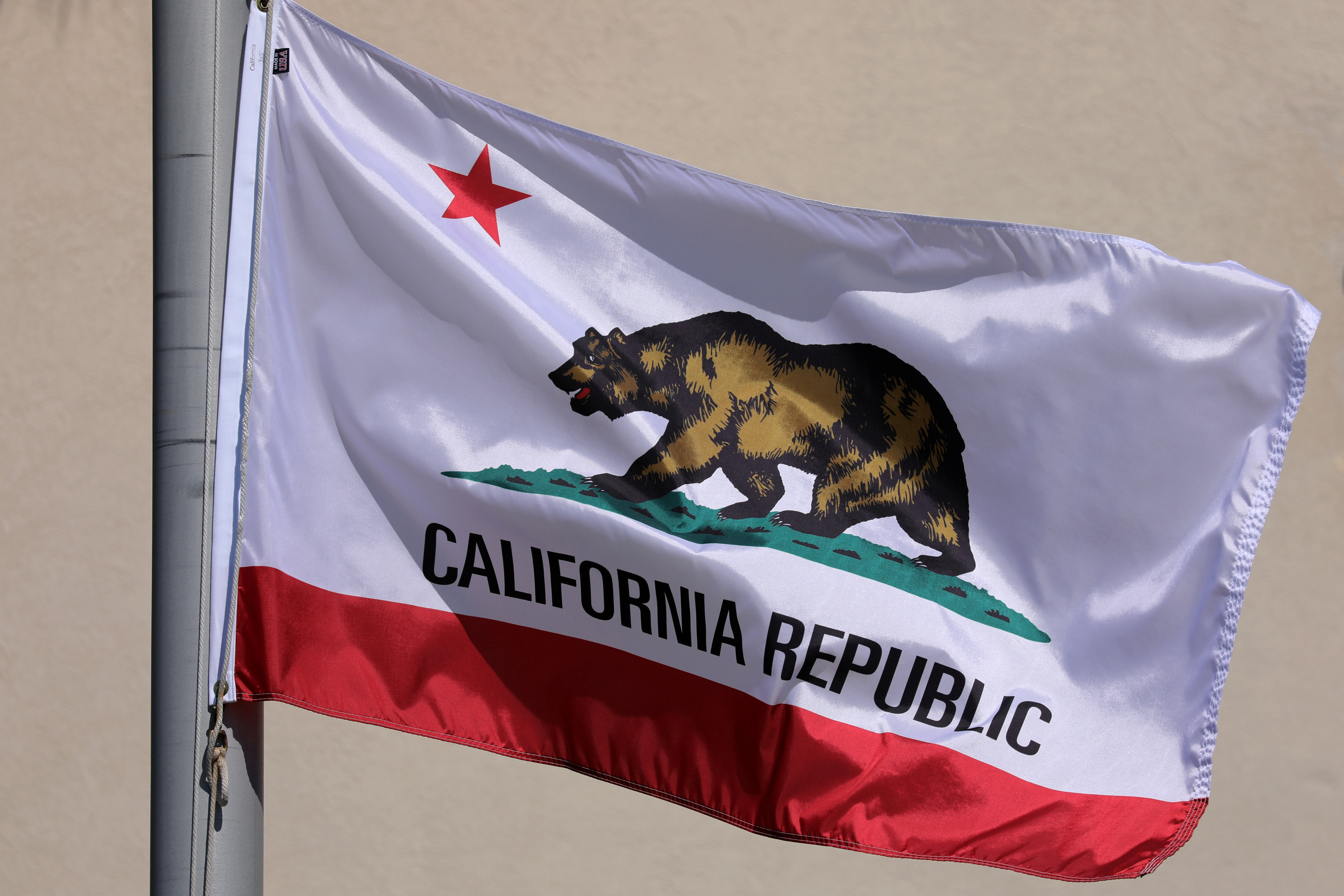 The state flag of California flies on a flag pole in San Diego, California, Oct. 6, 2017.