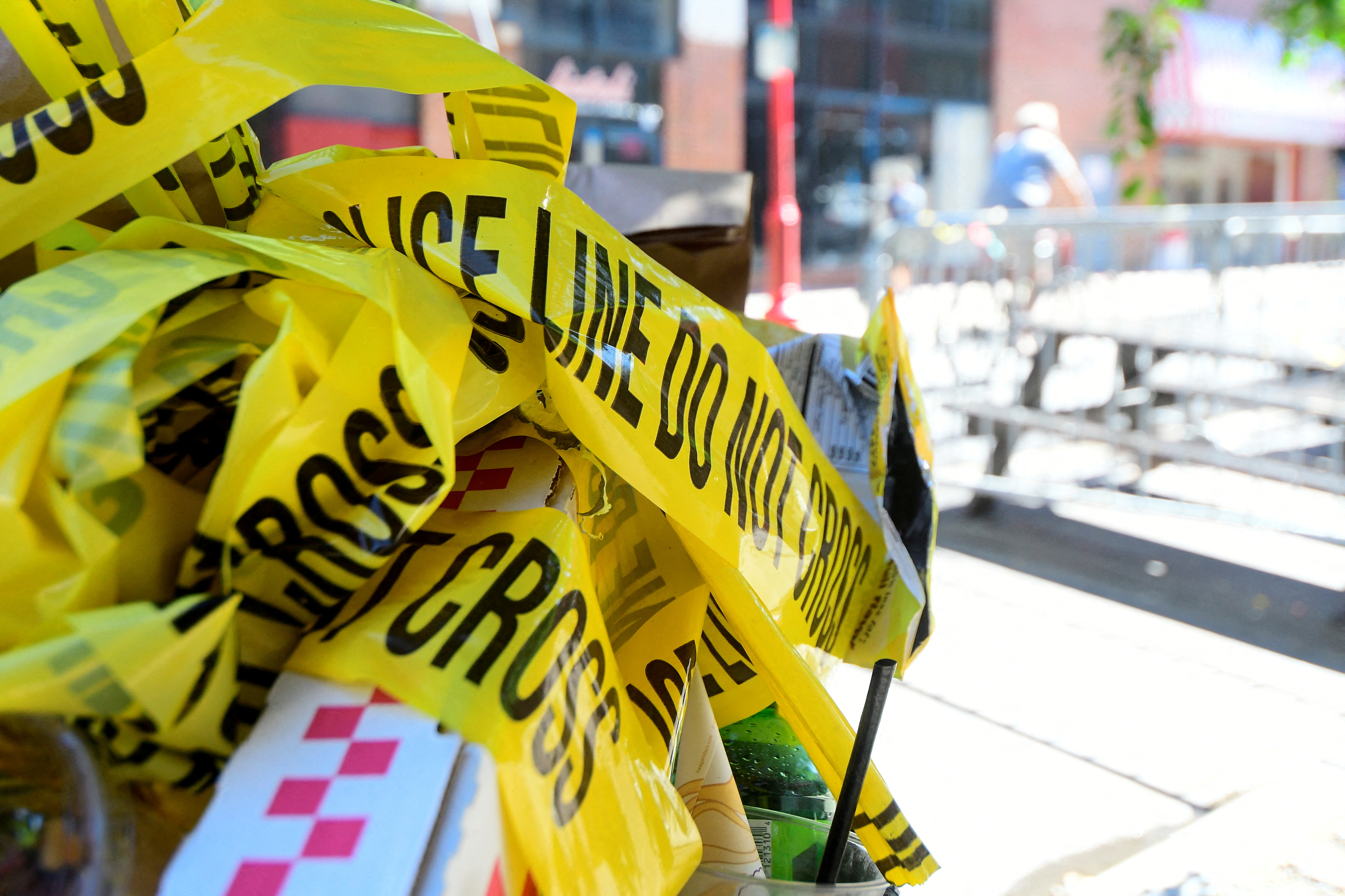 Police tape is pictured at a trash can on the street, at a crime scene after a deadly mass shooting on South Street in Philadelphia, Pennsylvania, June 5, 2022.