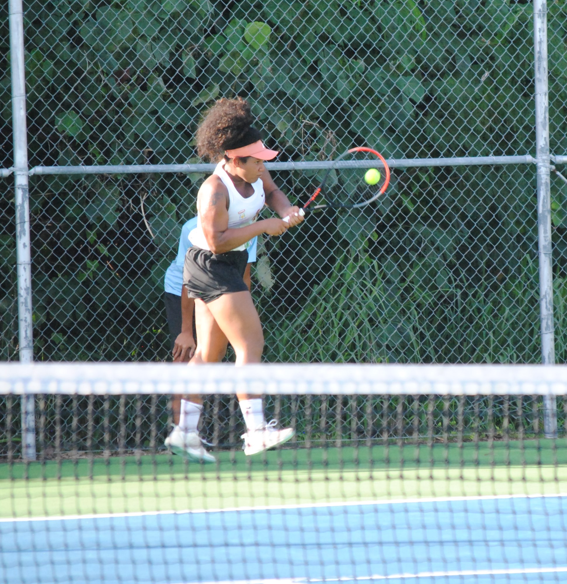 The NMI's Asia Raulerson connects the backhand return during the 2022 Pacific Mini Games tennis match for the bronze medal Saturday at an American Memorial Park tennis court.