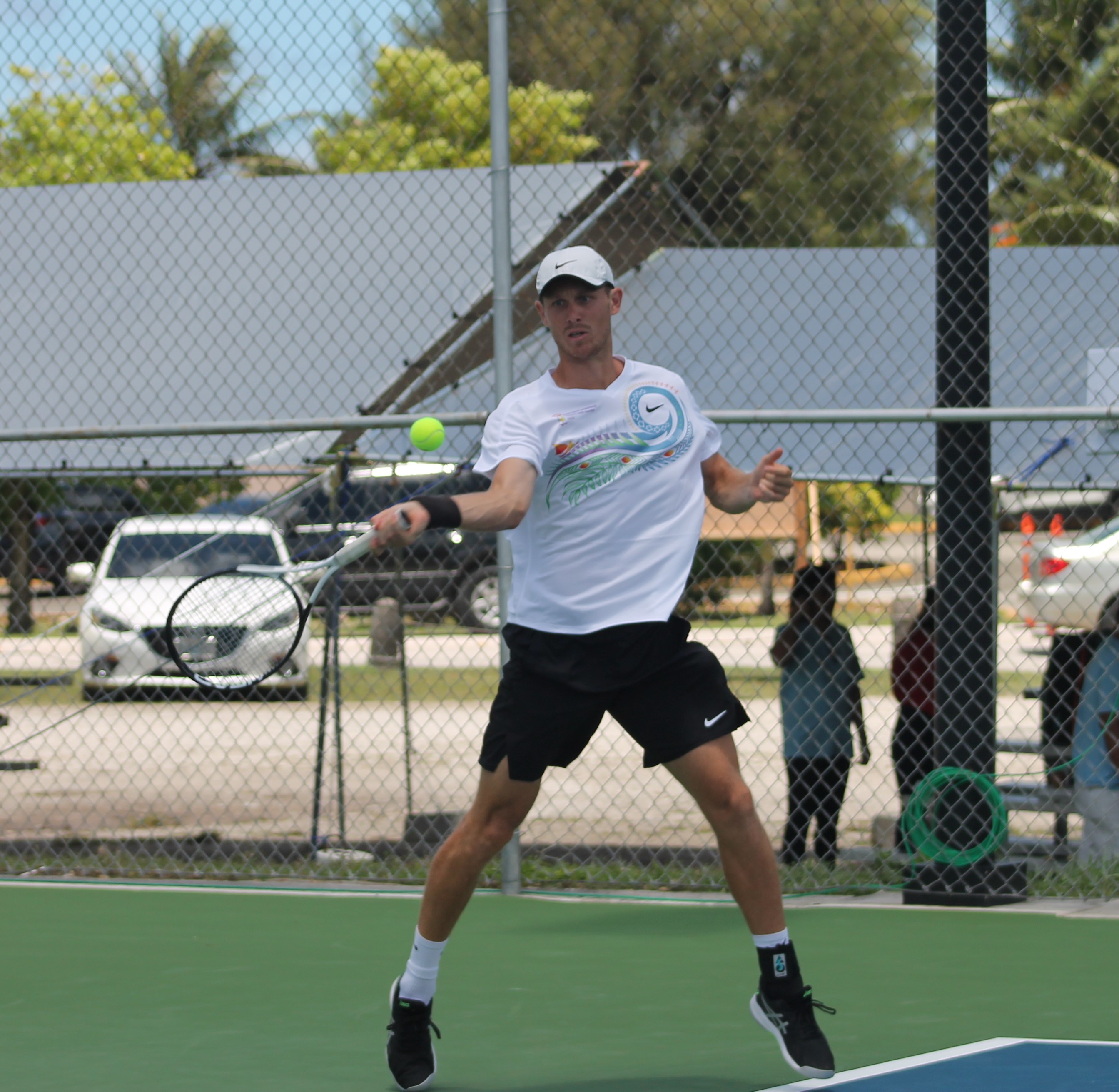 The NMI’s Colin Sinclair reaches out for the front hand return during the opening Pacific Mini Games tennis match Thursday against Kiribati at an American Memorial Park tennis court.