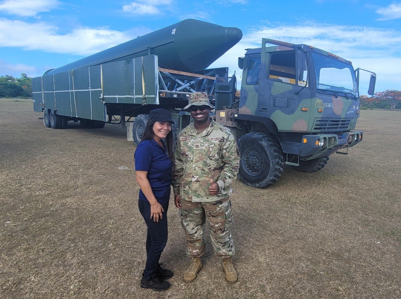 Special Assistant for Military Affairs Glenna S. Palacios, left, and Capt. Jaylon Woodson of Joint Region Marianas, right, pose for a photo in front of a High Vehicle Target.