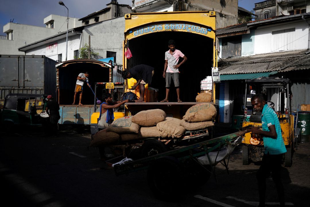 Laborers wait after unloading the sacks of rice at a wholesale market, amid the country's economic crisis in Colombo, Sri Lanka, May 20, 2022.