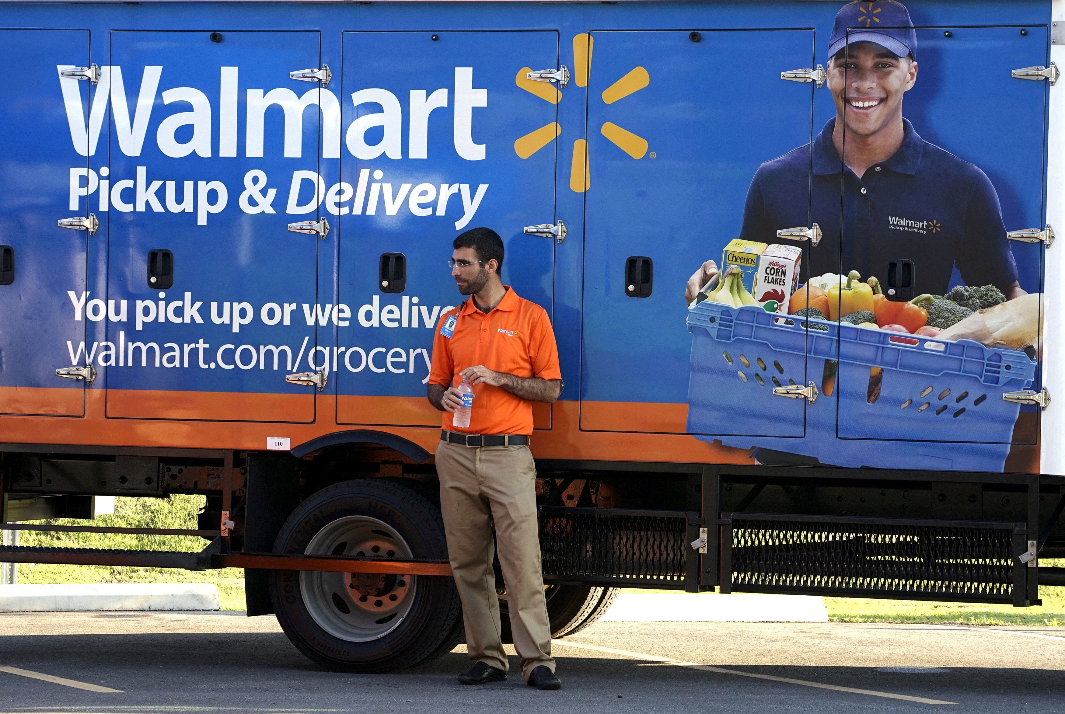 A Wal-Mart Pickup-Grocery employee waits next to a truck at a test store in Bentonville, Arkansas on June 4, 2015.