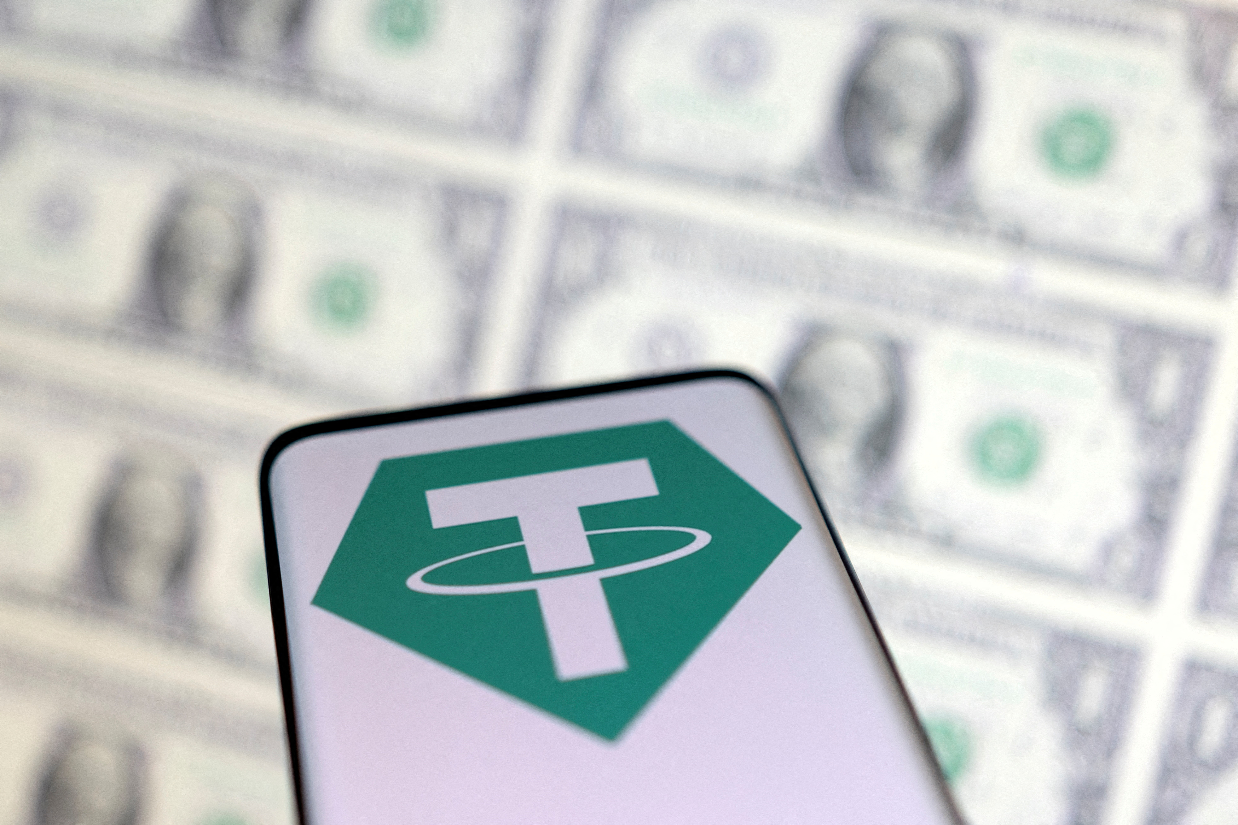 Smartphone with Tether logo is placed on displayed U.S. dollars in this illustration taken on May 12, 2022.