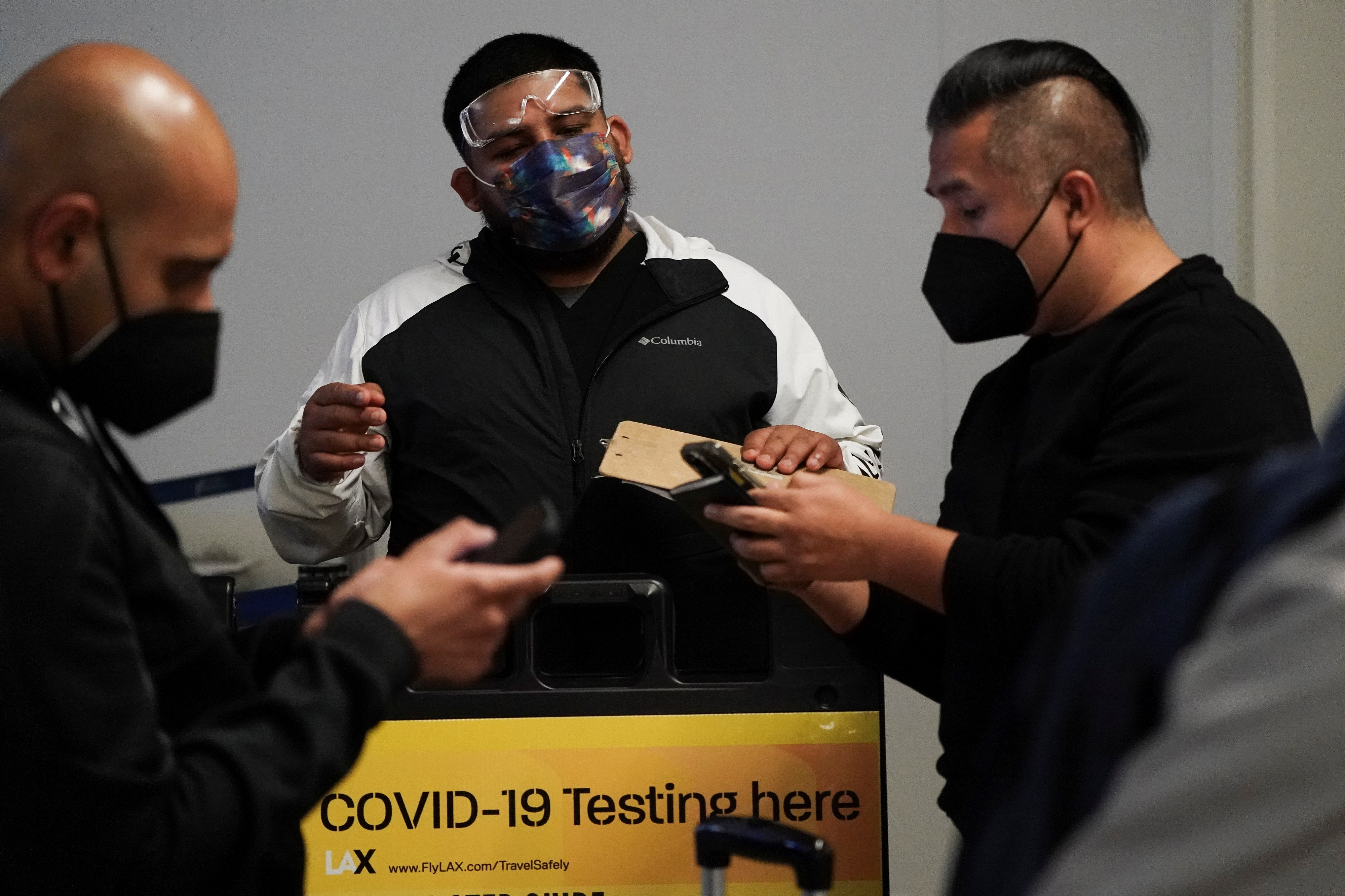 Travelers wait in line to get tests for the coronavirus disease at a pop-up clinic at Tom Bradley International Terminal at Los Angeles International Airport, California on Dec. 22, 2021.