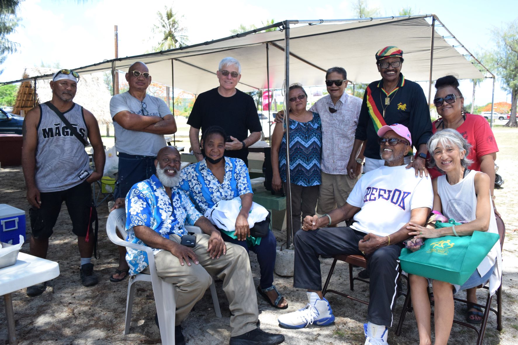 Juneteenth host, retired teacher Ambrose Bennett, second right, back row, with former Coastal Resources Management Director Dr. John Joyner, second right seated, Saipan Seventh-day Adventist School Principal Lylton Powell, left seated, teacher Debra Powell, second left seated, local artist Ben "Lamlam" San Nicolas, second left backrow, attorney Stephen Woodruff, center, Indigenous Affairs Program Manager Crispin Ogo, and other members of the local community.