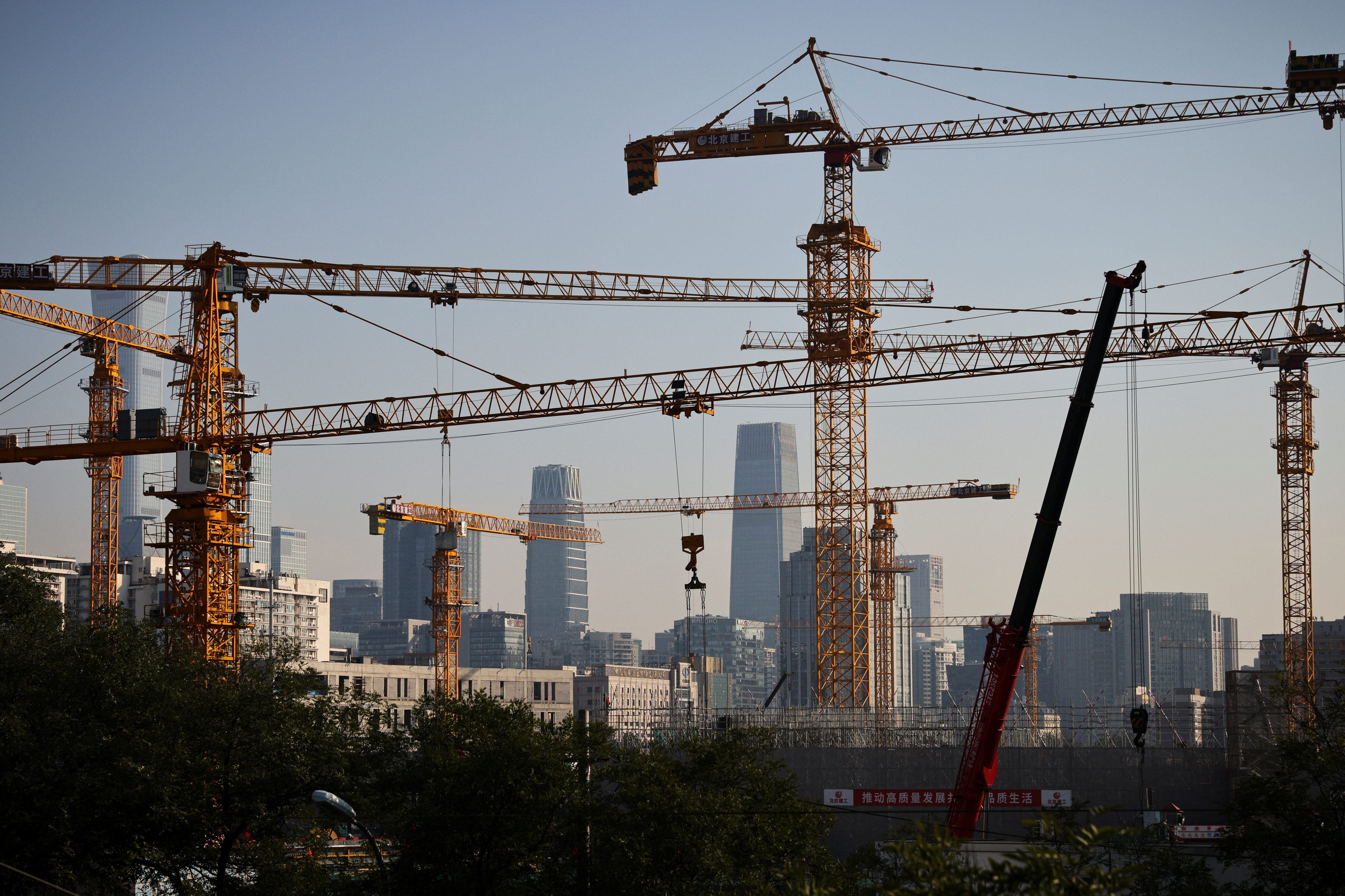 A view shows cranes in front of the skyline of the Central Business District in Beijing, China, Oct. 18, 2021.