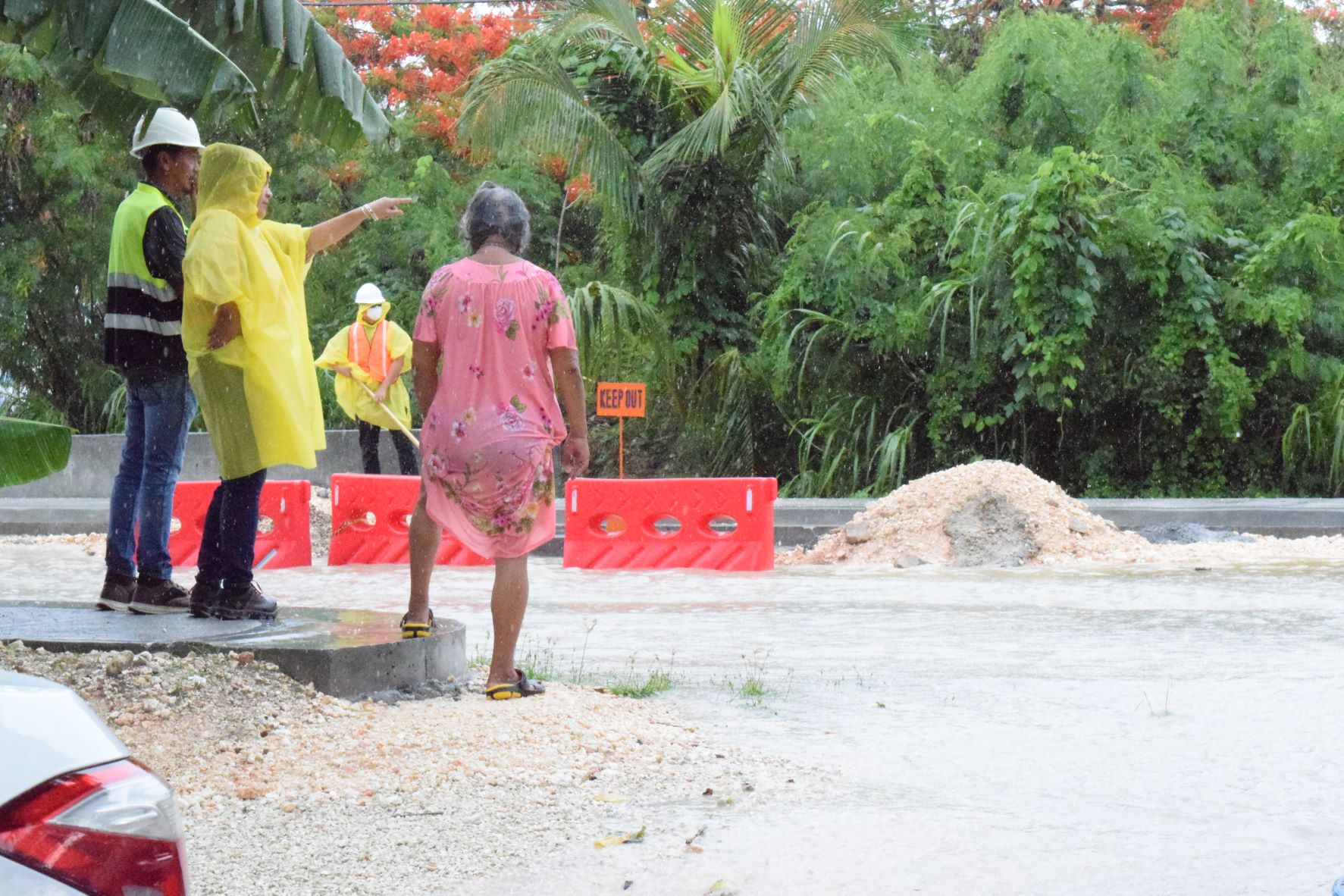 Department of Public Works Highway Administrator Lorraine Villagomez, 2nd left, gestures as she talks with Quartermaster Road resident Rosa Rabauliman about how DPW will address the flooding in the area on Tuesday following a downpour.