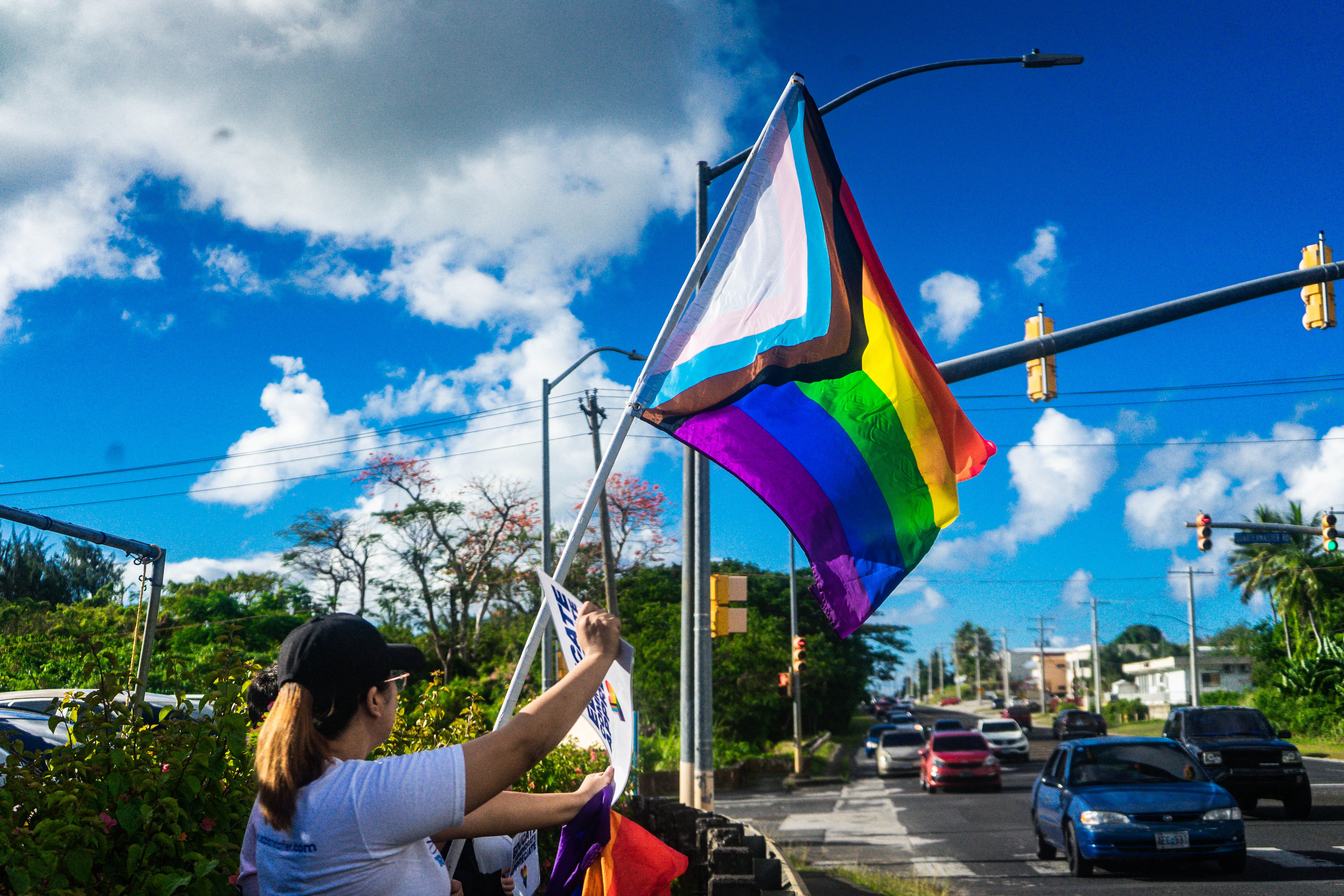 A supporter waves a PRIDE flag at the NMI Democratic Party's headquarters on June 3.