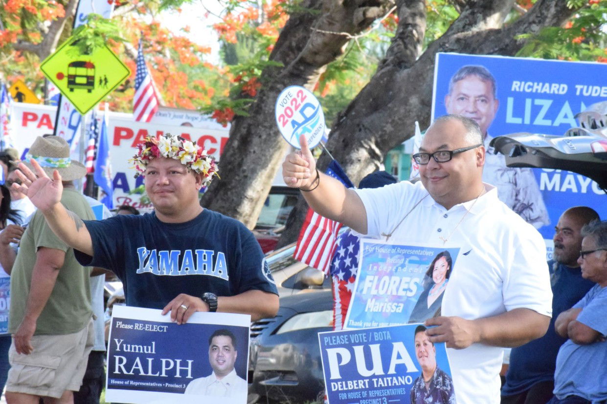 Precinct 3 independent House candidates Delbert Pua and Vice Speaker Blas Jonathan Attao wave at motorists.