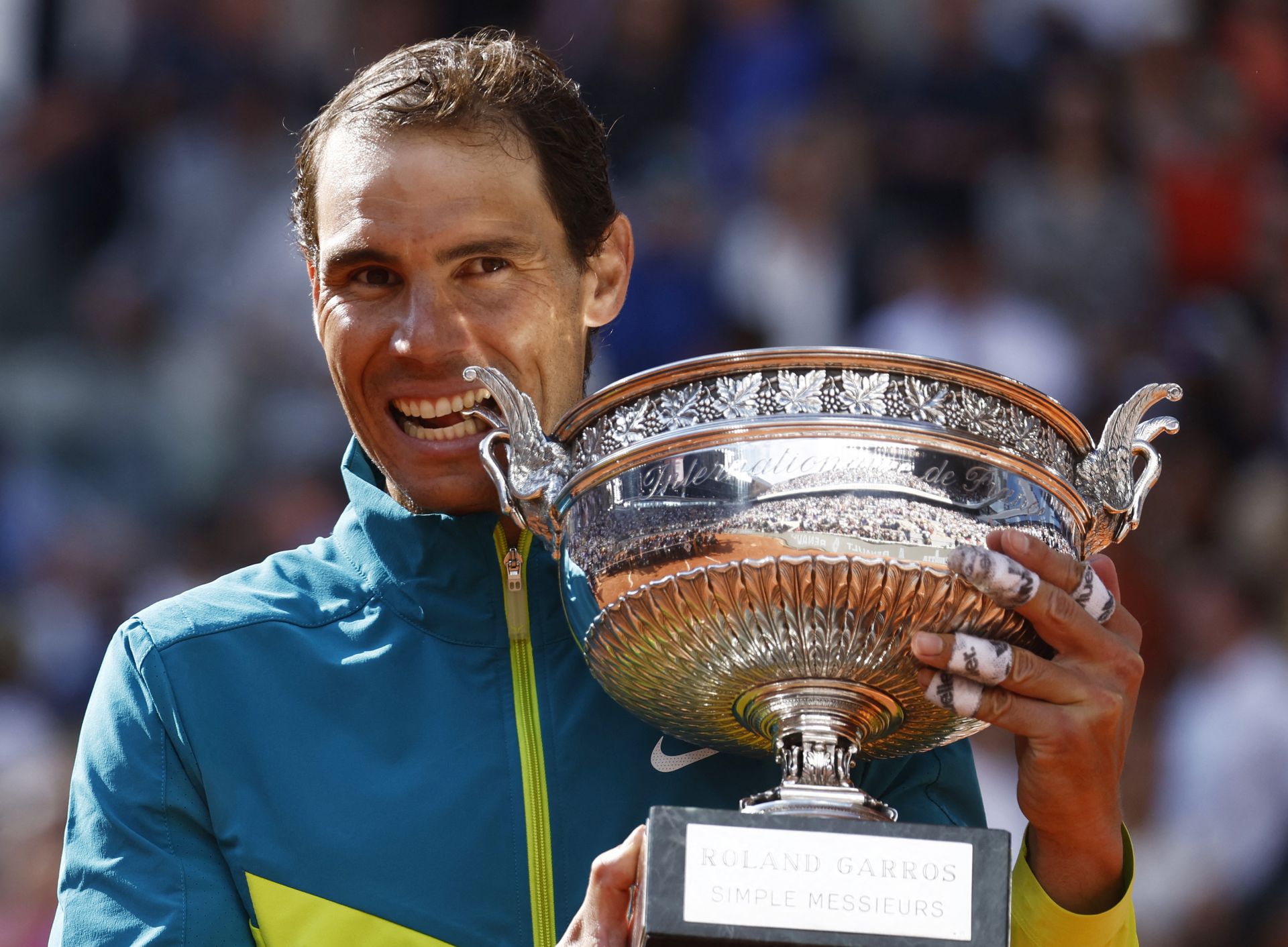 Spain's Rafael Nadal bites the trophy to celebrate winning the men's singles final against Norway's Casper Ruud in the  French Open at Roland Garros, Paris, France on June 5, 2022.