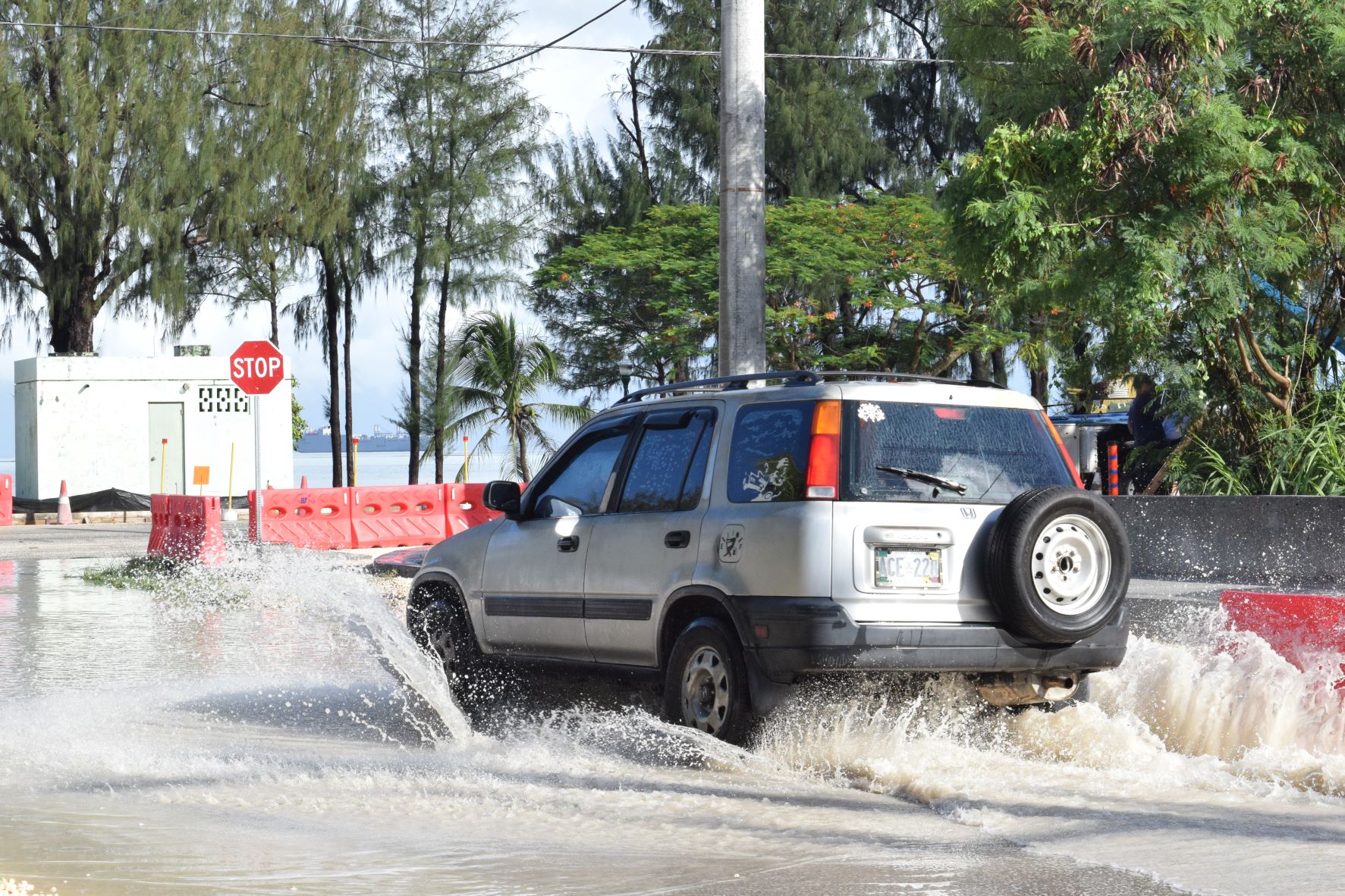 A car drives through a flooded portion of Quartermaster St. near Beach Rd. after a downpour on Friday.