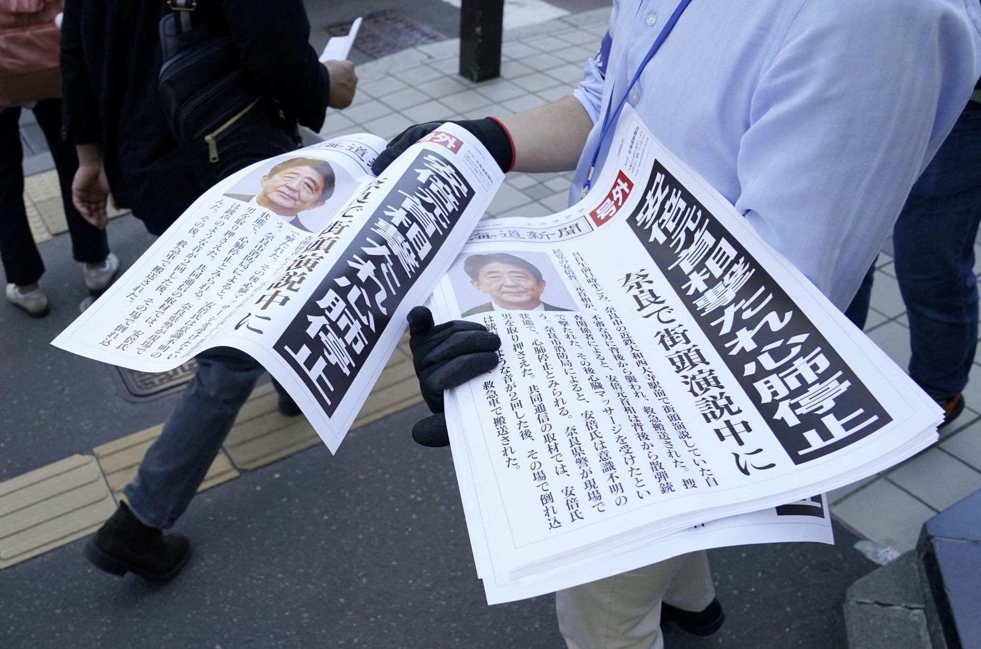 Copies of an extra edition of a newspaper is handed out to pedestrians in Sapporo, after former Japanese Prime Minister Shinzo Abe was shot, in Sapporo, Japan on July 8, 2022 in this photo taken by Kyodo.