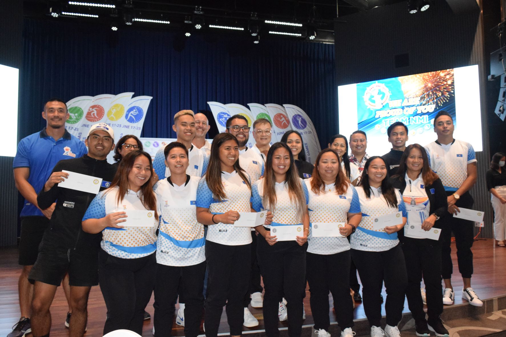 The NMI badminton team members with their awards.