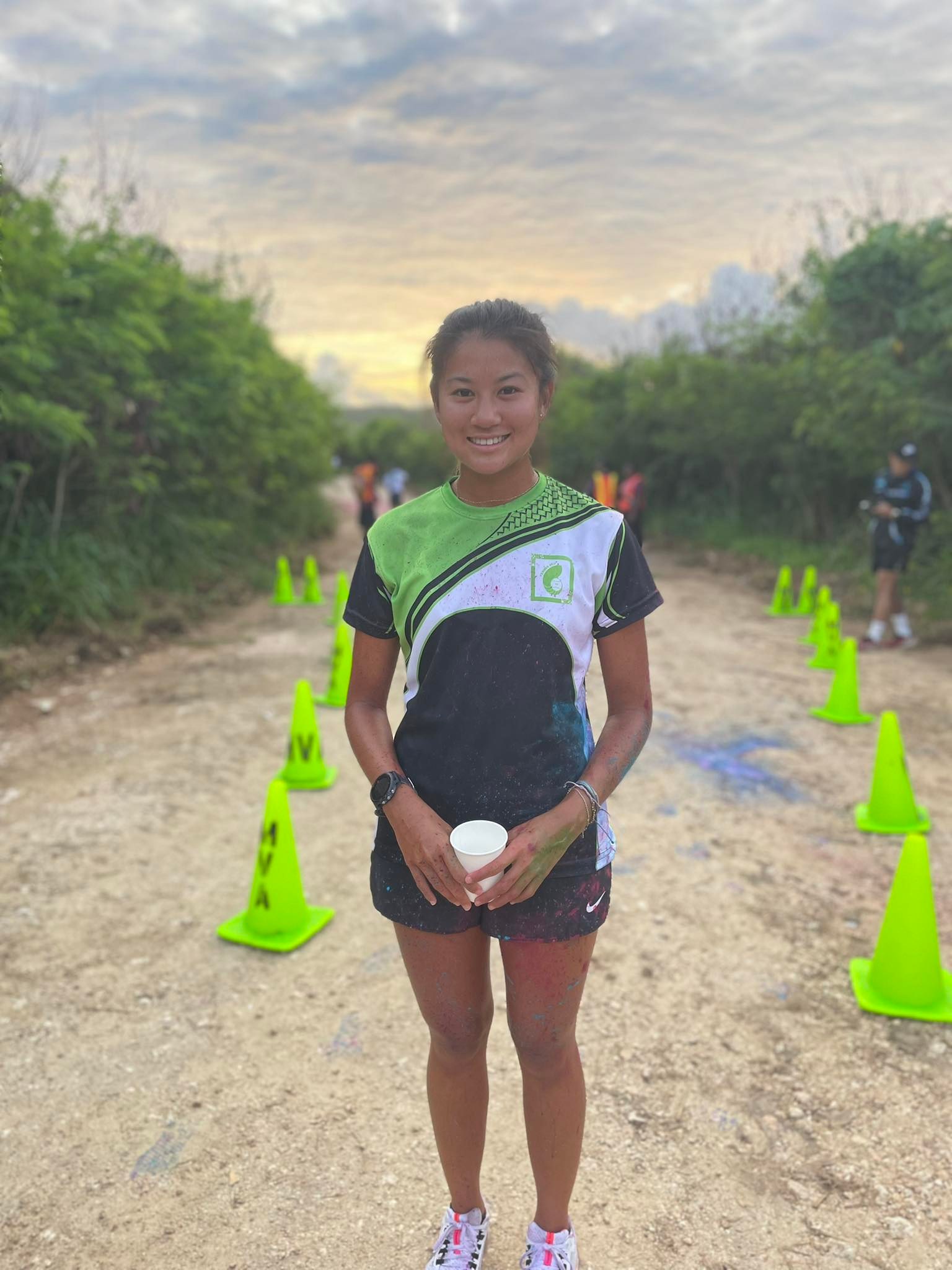 Tania Tan smiles after claiming first place in the women's division of the Acha'ikak Kulot 5K color run at Laolao Bay on Saturday.