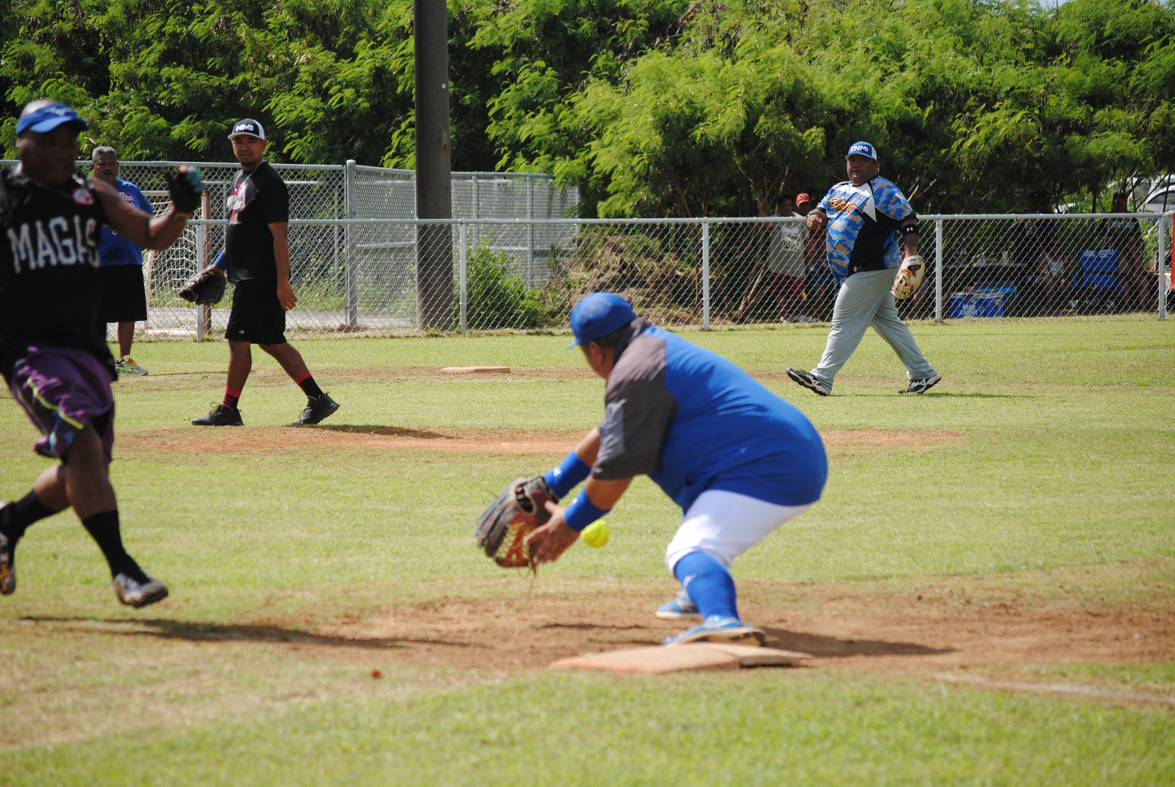 Man Amigos' 1st baseman Derron Flores extends for the catch thrown by 3rd baseman Manny Sablan for the out during a 2022 Budweiser Belau Amateur Softball League game Sunday at the Dandan baseball field.