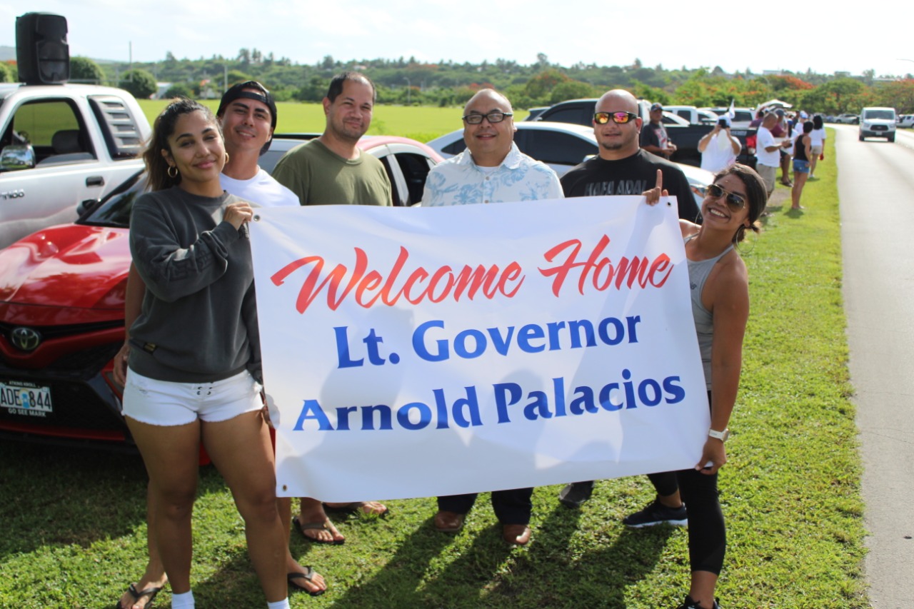 Vice Speaker Blas Jonathan Attao, center, and other AD 2022 supporters hold a welcome banner for Lt. Gov. Arnold I. Palacios  on Airport Road, Saturday.