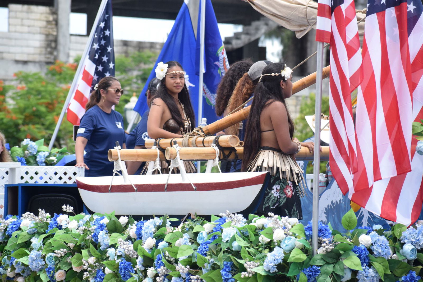 A small boat surrounded by American flags is depicted on Triple J's float.
