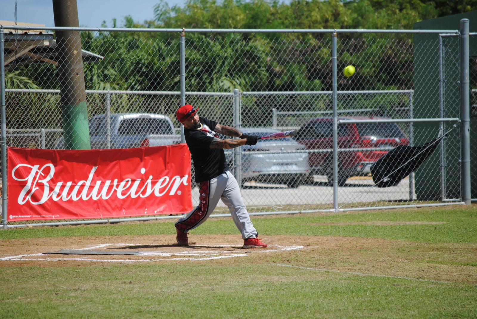Man Amigos' James connects the hit to right outfield for a double during a  BASA Softball League game at the Dandan baseball field on Sunday.