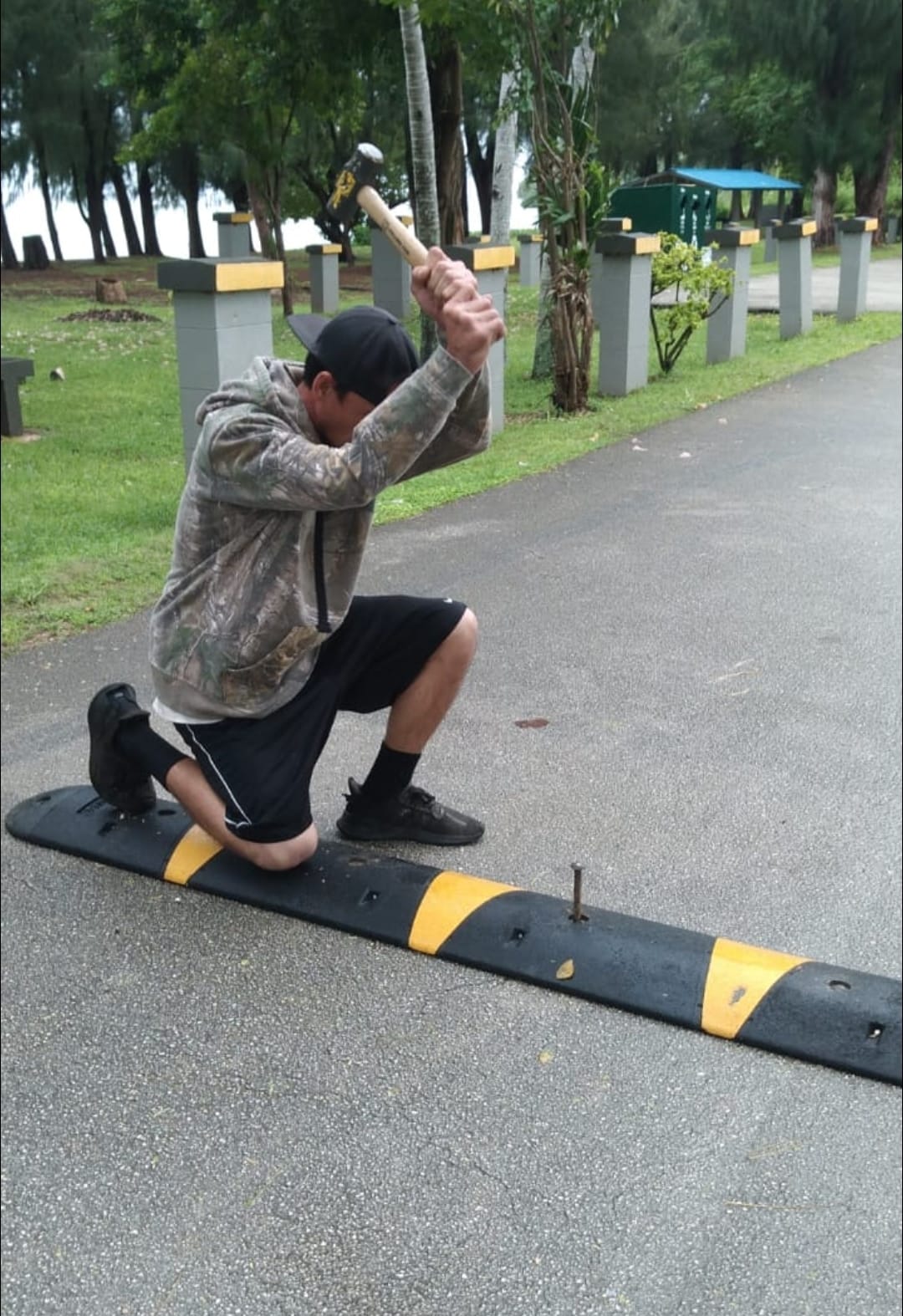 One of Rep. Joel Camacho's staffers install a brand new speed bump at Paupau Beach.