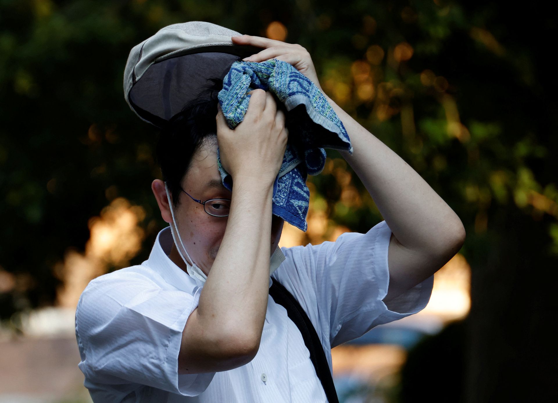 A man wipes off sweat with a towel at a park under the strain of Tokyo's hottest June streak since 1875 in Tokyo, Japan, June 30, 2022.