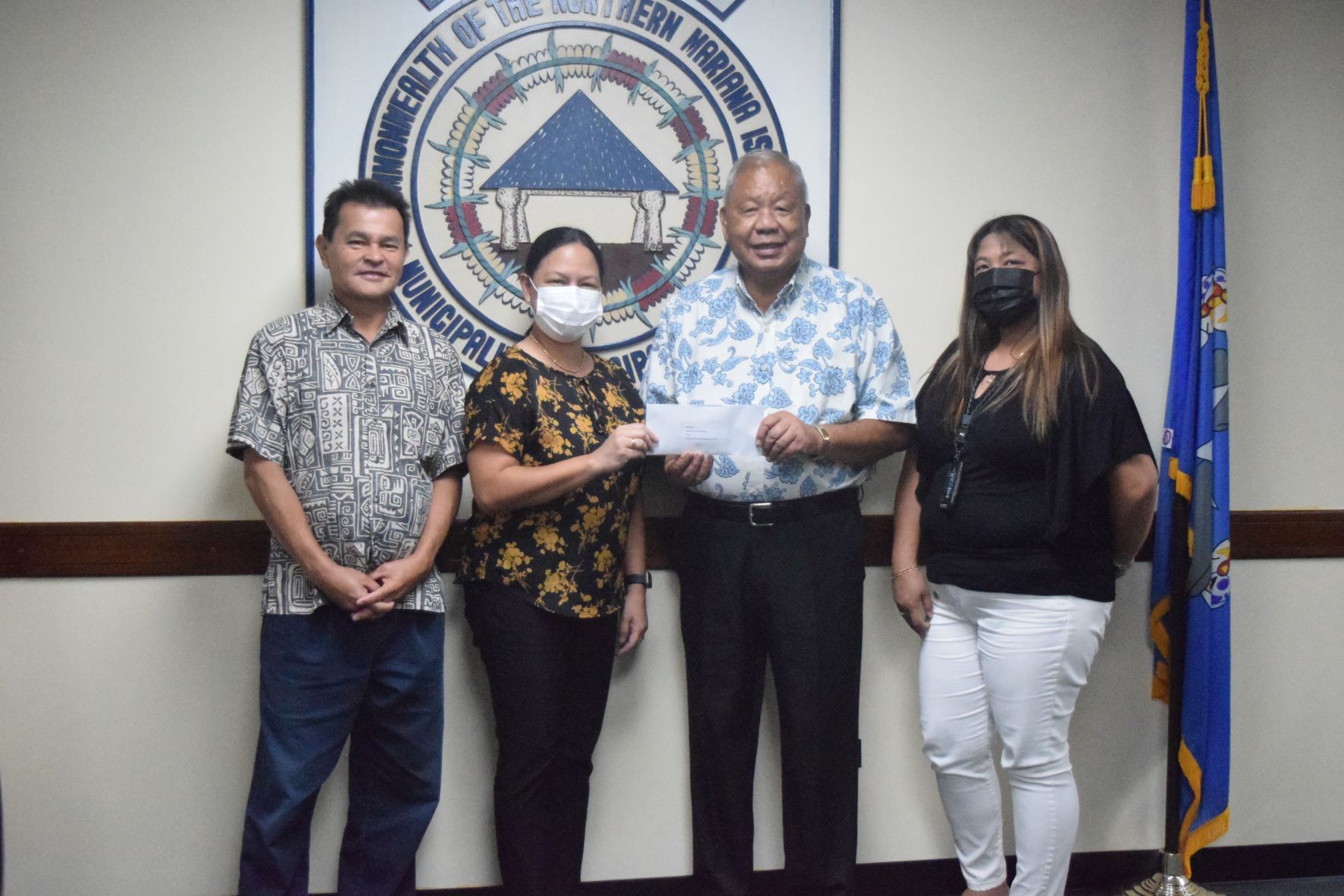 Tona Tudela of the Department of Commerce receives their share of the $4,000 second prize from Saipan Mayor David Apatang. Also in photo are Glennis Gamboa-Licop, also of the Department of Commerce, right, and special assistant to Saipan mayor Henry Hofschneider.
