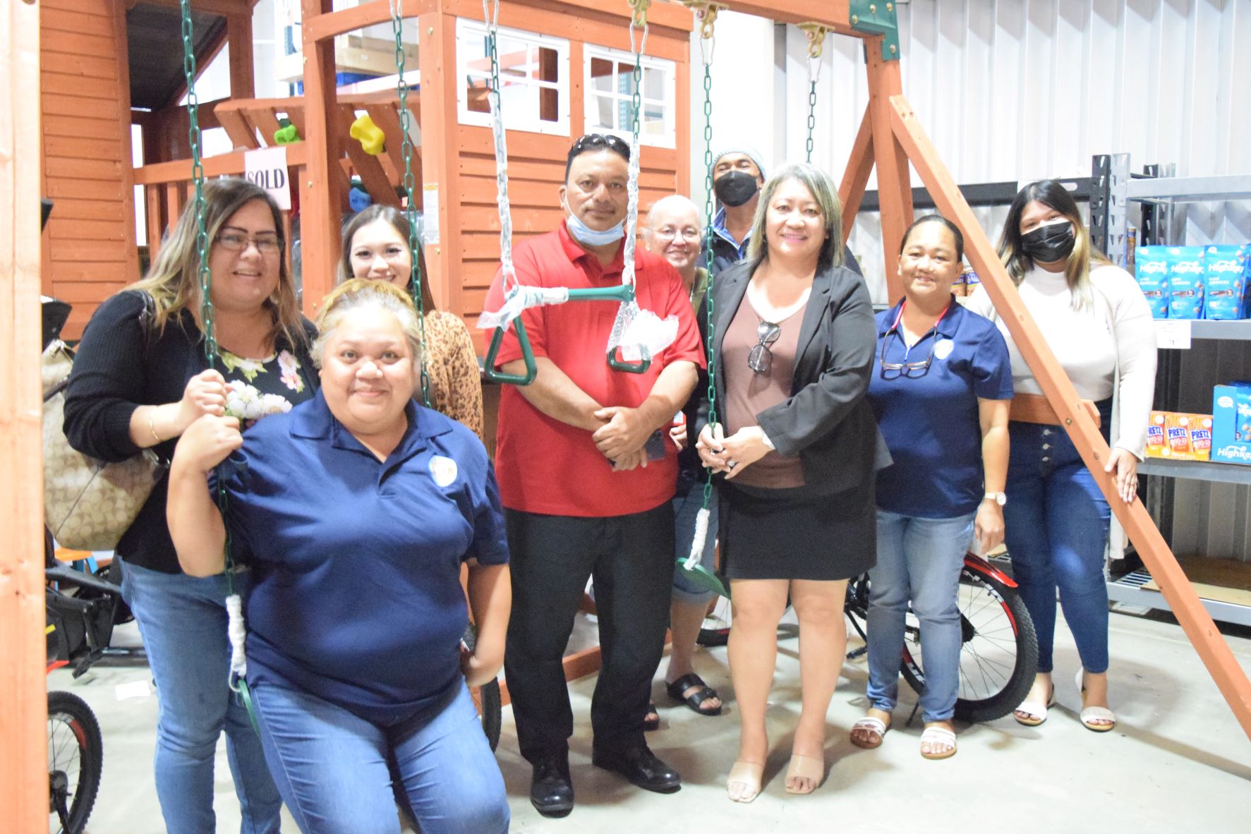 Sen. Edith Deleon Guerrero, third right, with Division of Youth Services Administrator Vivian Sablan, left, and DYS staff next to a brand new playhouse and swing set at Joeten Superstore in San Jose on Monday. With them are DYS staffers Grace Babauta, fifth right back row; Kevin Deleon Guerrero, center; Children’s Shelter Supervisor Junne Masga, second right; and child protective services staff member Melycher Sablan, second left.
