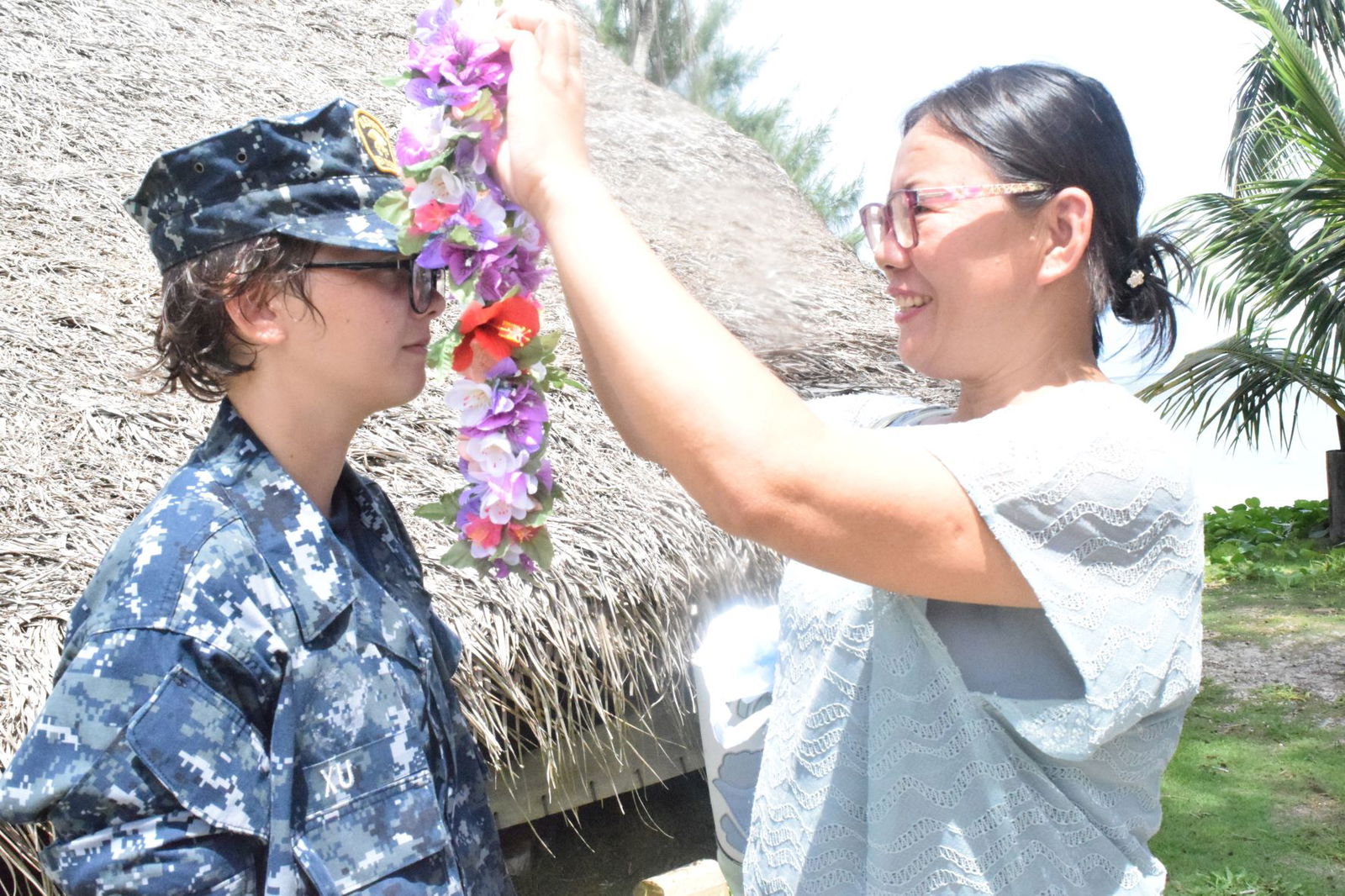 Lan Yua Xu, right, puts a lei on her daughter, Sea Cadet Angela (Liam) Xu.