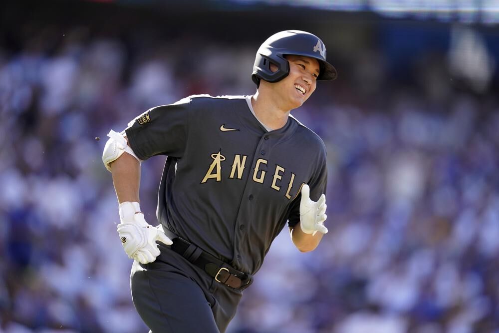 American League's Shohei Ohtani of the Los Angeles Angels smiles as he round first base with a single during the first inning of the MLB All-Star baseball game against the American League, Tuesday, July 19, 2022, in Los Angeles.