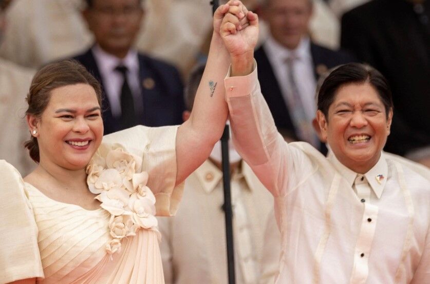 Philippine Vice President Sara Duterte raises the arm of President Ferdinand "Bongbong" Marcos Jr. during the inauguration ceremony at the National Museum in Manila on June 30, 2022.