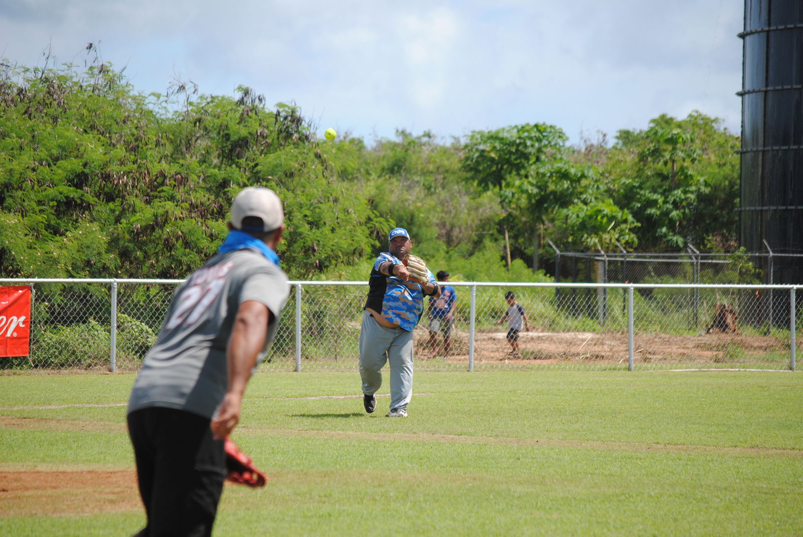 Man Amigos' third baseman Manny throws to first baseman Mark for the out during a  BASA Softball League game at the Dandan baseball field on Sunday.