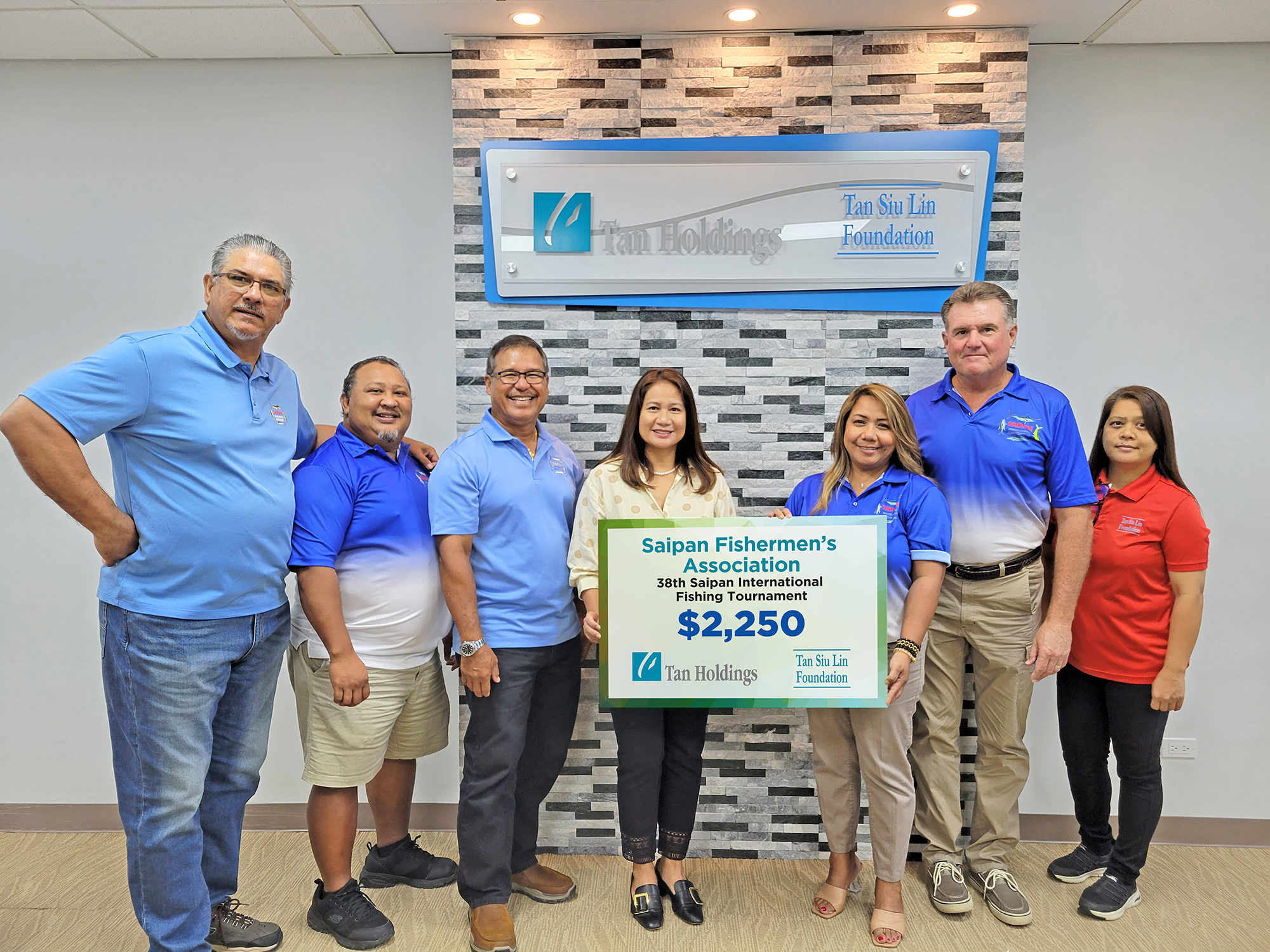 Tan Siu Lin Foundation executive director Merlie Tolentino, center, presents a ceremonial check to Saipan Fishermen’s Association officers during a turnover ceremony  Tuesday in Garapan.