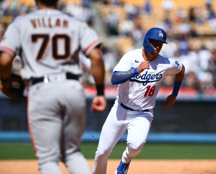 Los Angeles Dodgers designated hitter Jake Lamb (18) runs into home base after second baseman Gavin Lux (9) hits a single against the San Francisco Giants during the seventh inning at Dodger Stadium in Los Angeles, California, July 24, 2022.