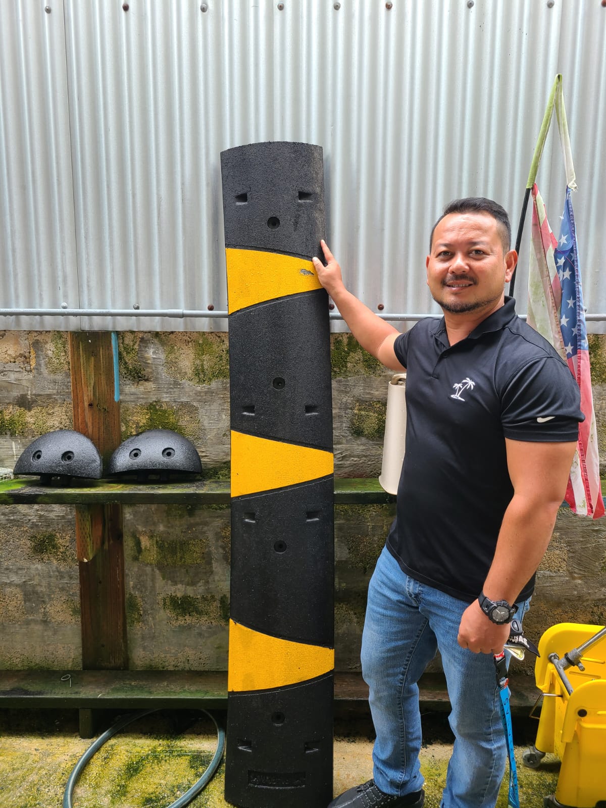 Rep. Joel Camacho presents one of the speed bumps he purchased for Paupau Beach.