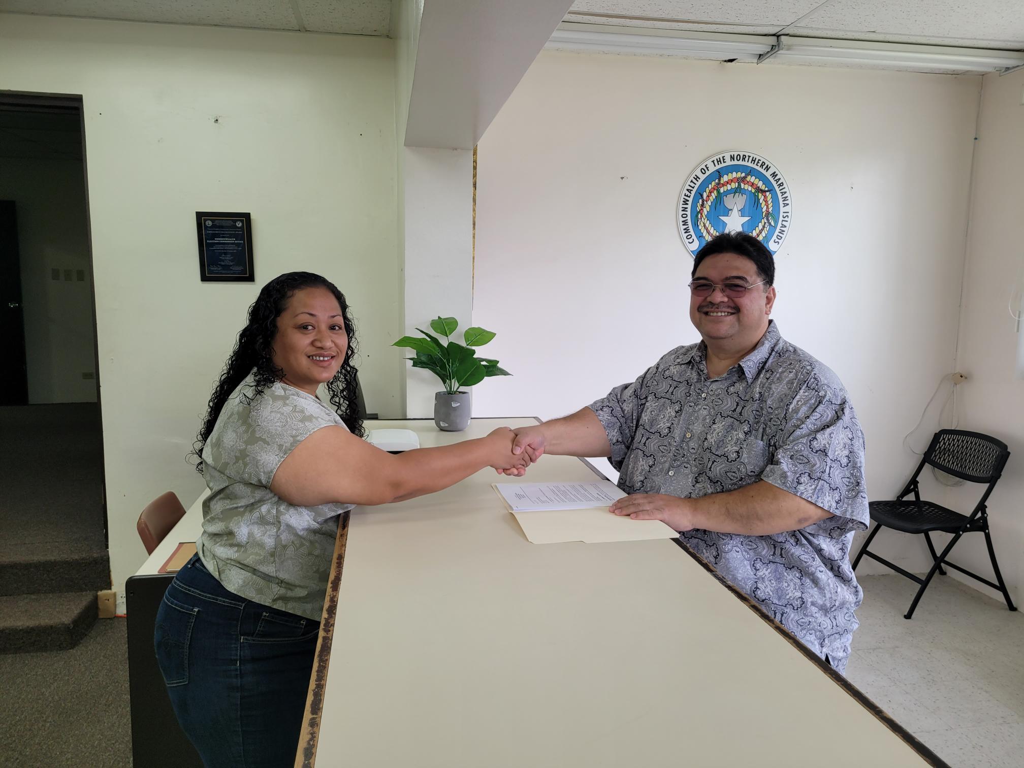 Superior Court Associate Judge Joseph N. Camacho, right, shakes hands with Commonwealth Election Commission Executive Director Kayla Igitol after submitting his letter of retention Friday morning at the CEC office.