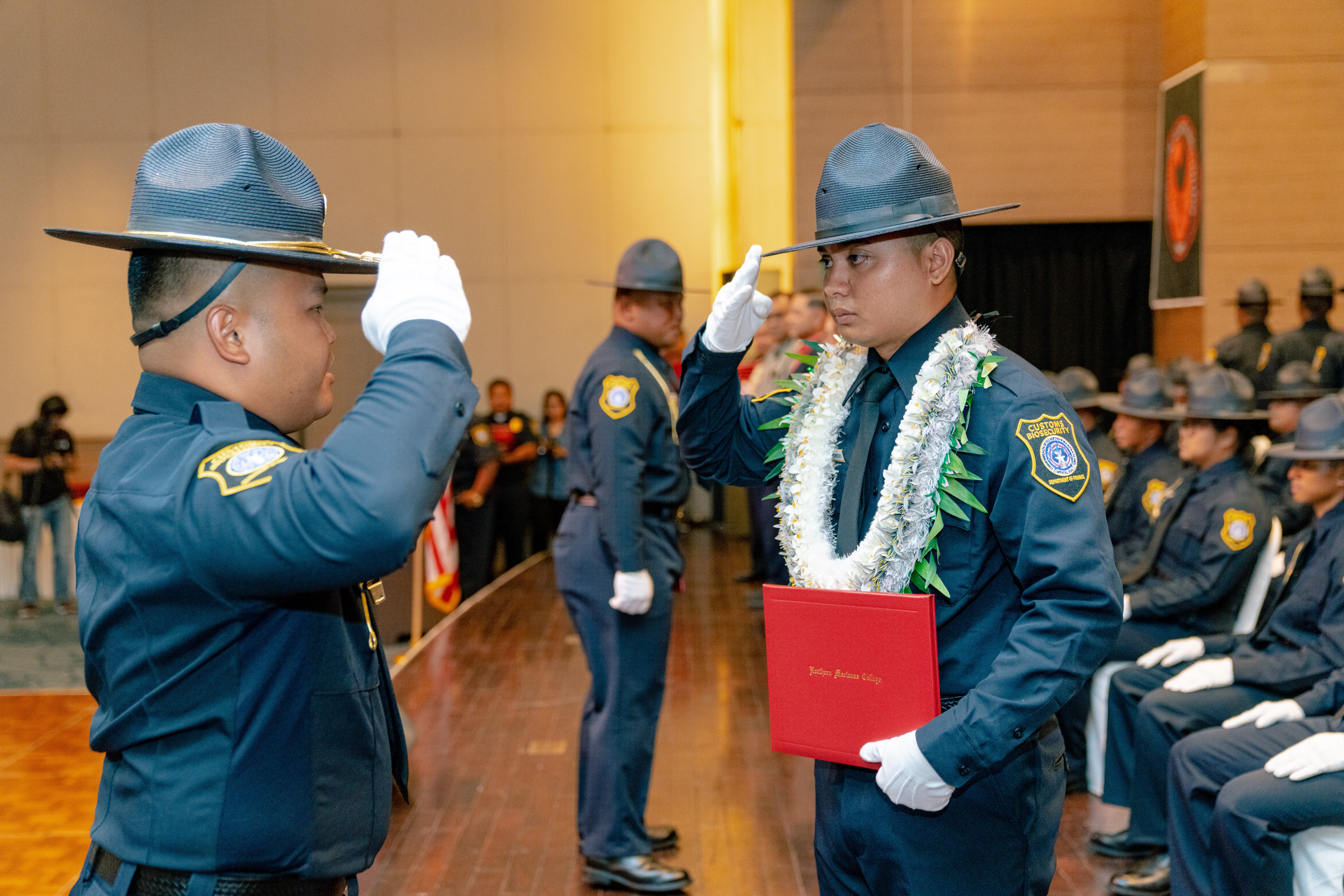 Tindin Leon Guerrero salutes Drill Instructor Mark Manaluz upon receiving his badge. Leon Guerrero was the class salutatorian and the Most Physically Fit awardee.