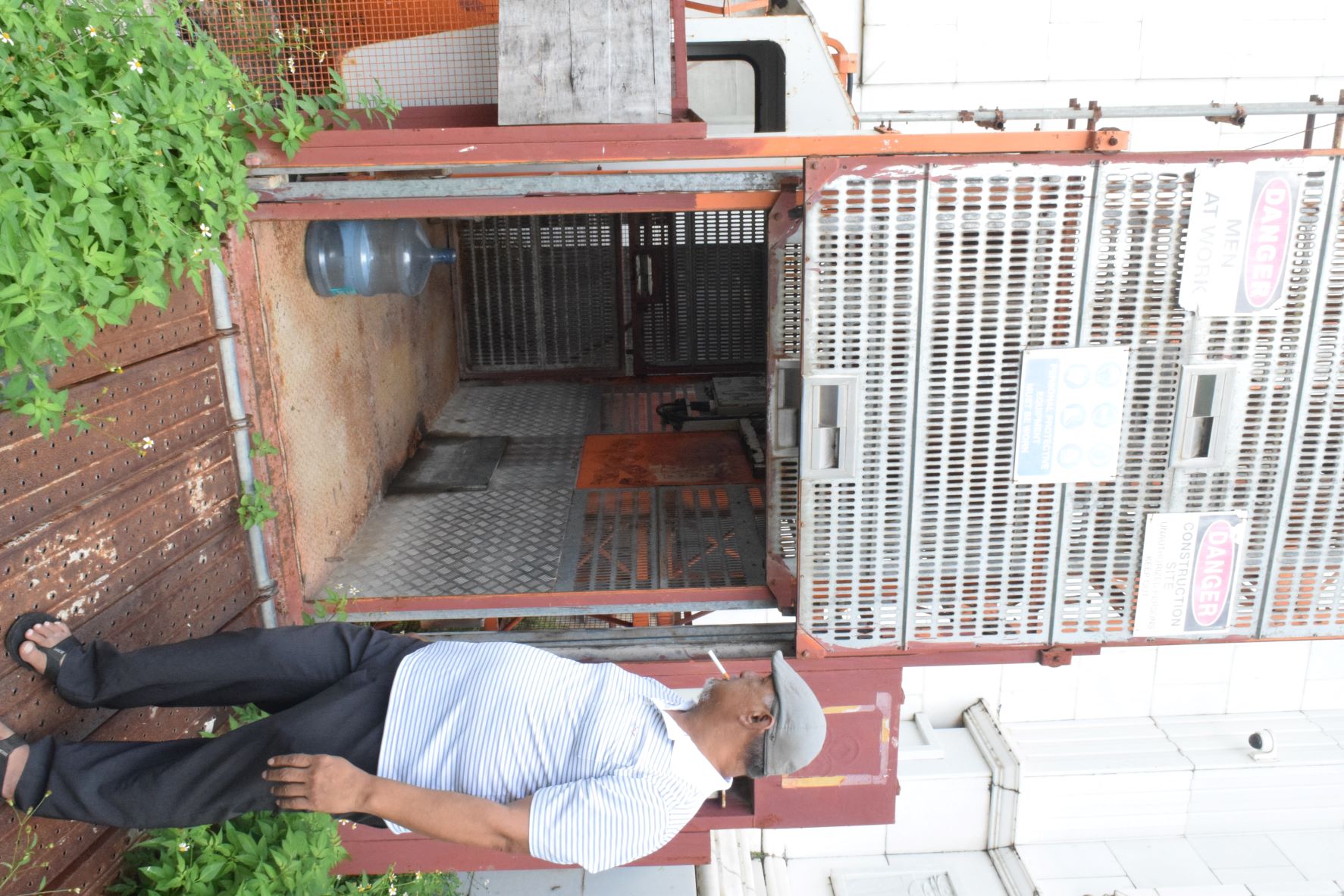 Former Imperial Pacific International construction team leader Jesse Aquiningoc looks at the rusty elevator at the unfinished IPI building in this photo taken two months ago.