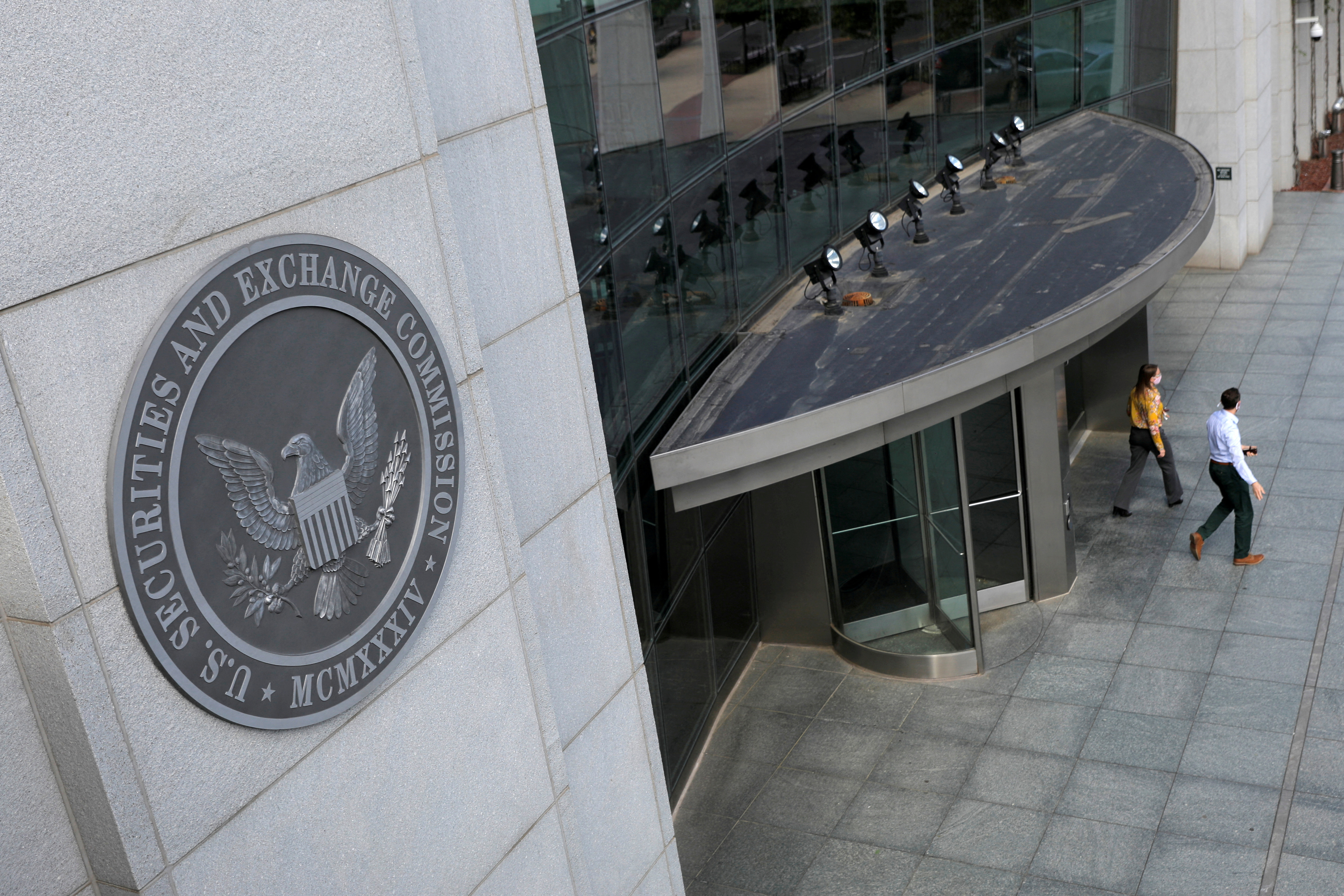 People exit the headquarters of the U.S. Securities and Exchange Commission in Washington, D.C.,  May 12, 2021.