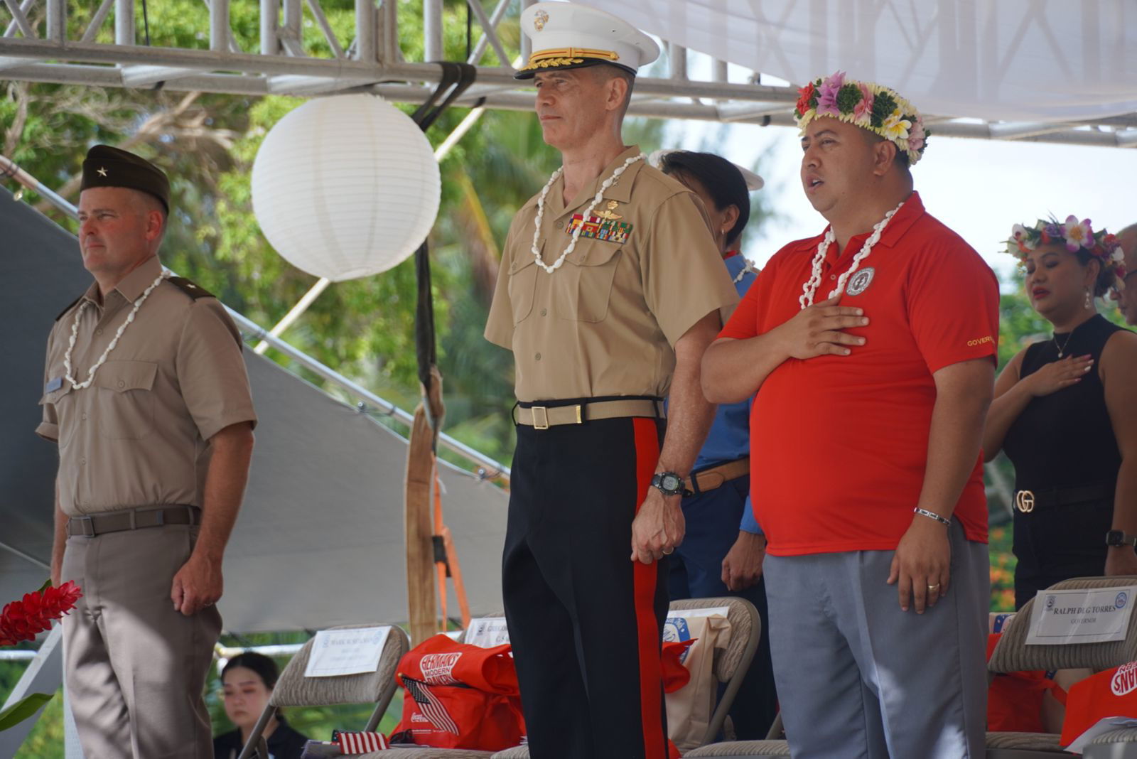 Gov. Ralph DLG Torres, Maj. Gen. Mark Hashimoto, lawmakers, other military officials, and community members stand for the signing of the Commonwealth anthem.