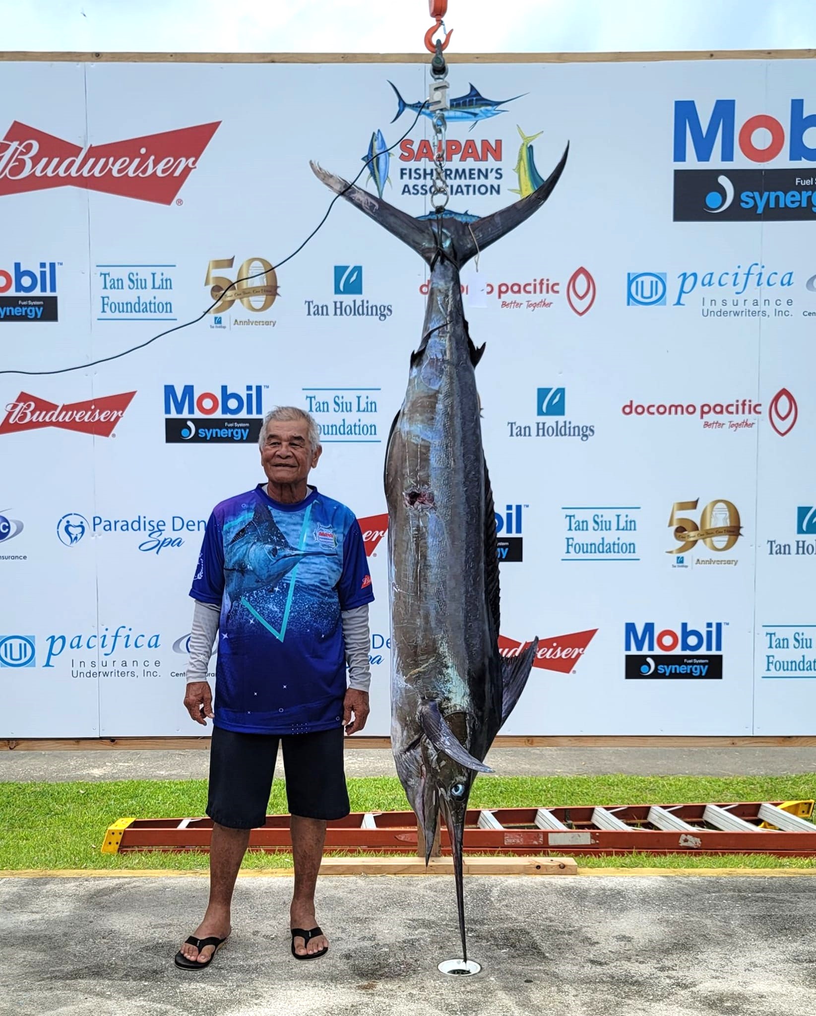 Juan I. Tenorio of Rose 1 poses with a 131.5-pound Marlin which won the grand prize in the 38th Saipan International Fishing Derby on Saturday at Smiling Cove Marina.