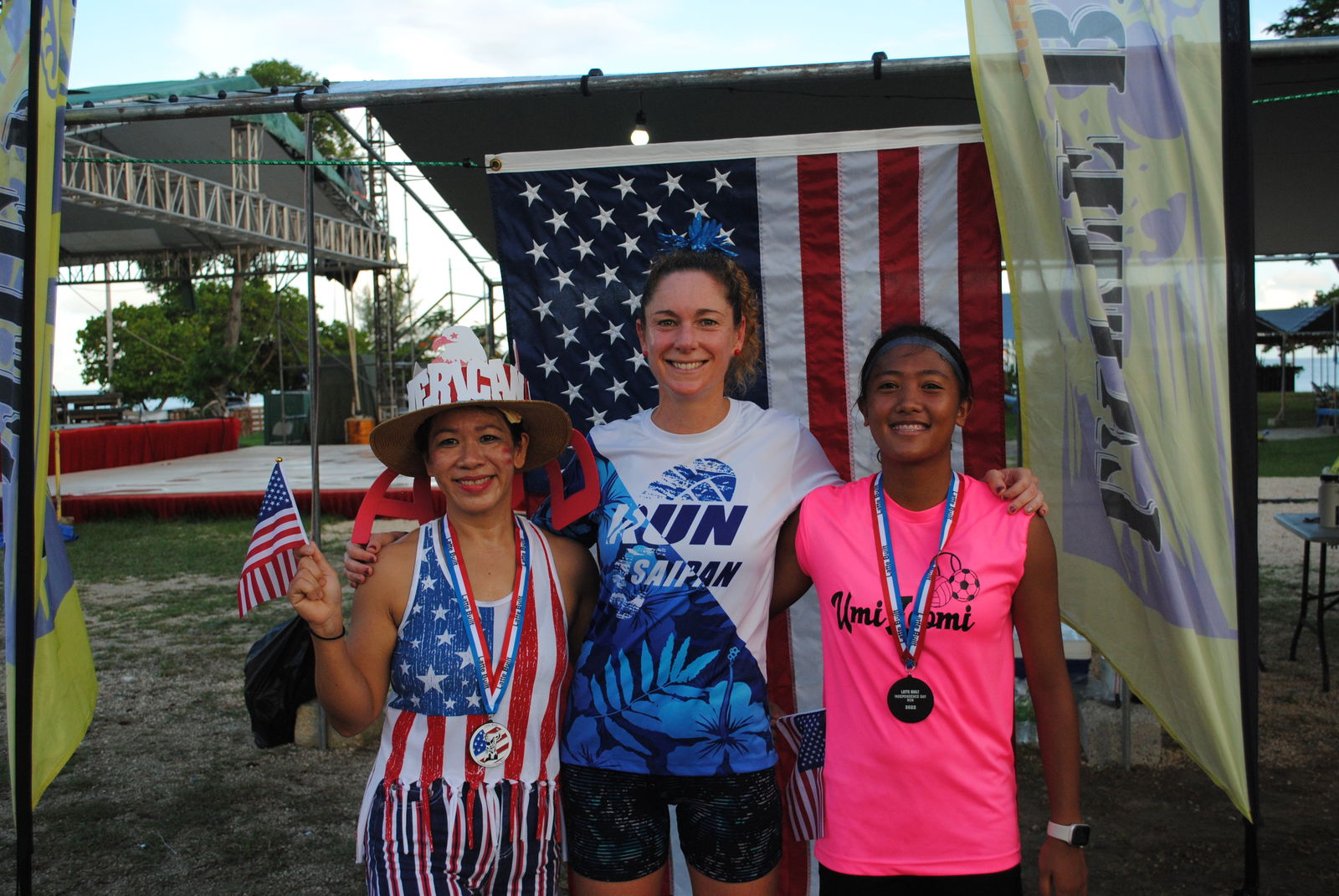 Lily Muldoon, center, poses with Rosemarie Chisato, left, and Kaithlyn Chavez after completing the 2nd Annual 4th of July two-mile race at the Garapan Fishing Base.