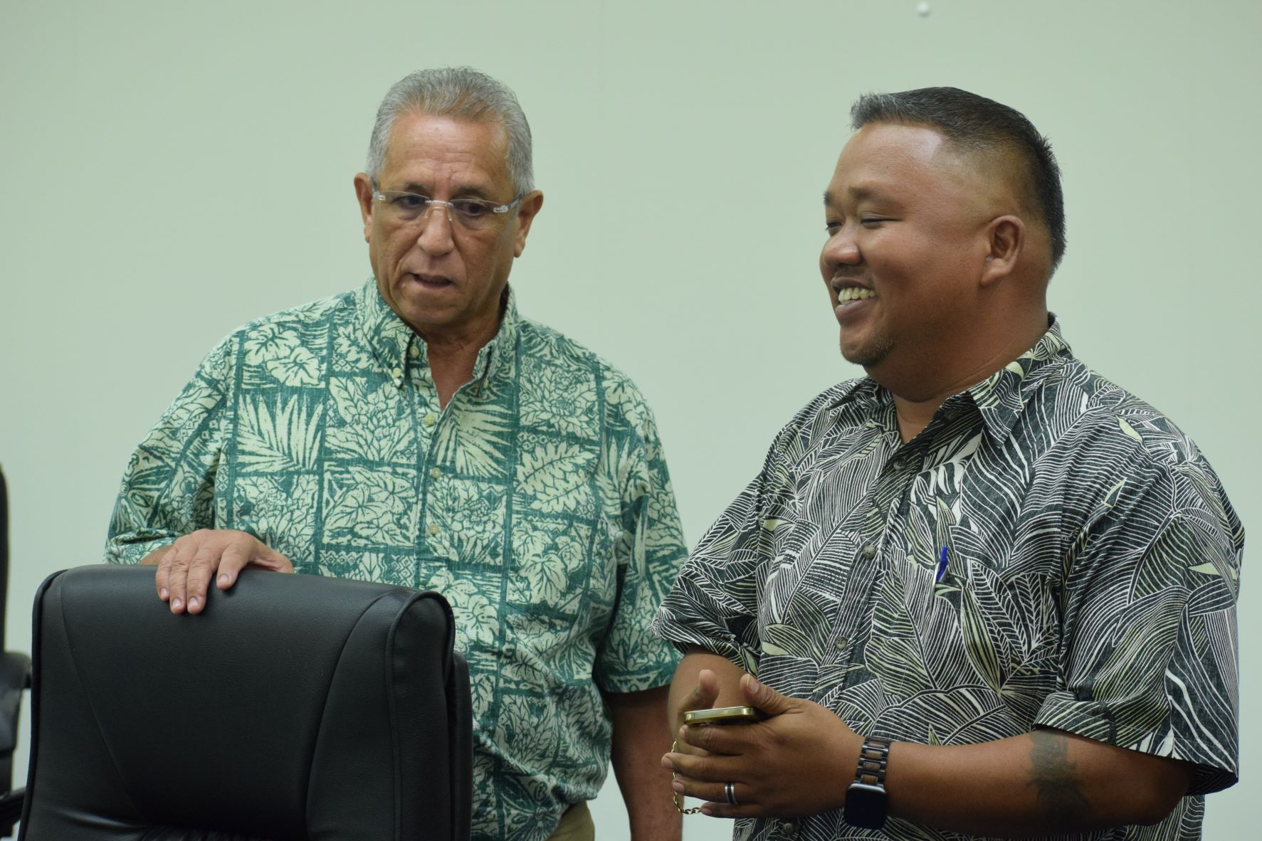 House Minority Leader Angel Demapan, right, smiles as he listens to Rep. Joseph Leepan T. Guerrero during a break from a House session.