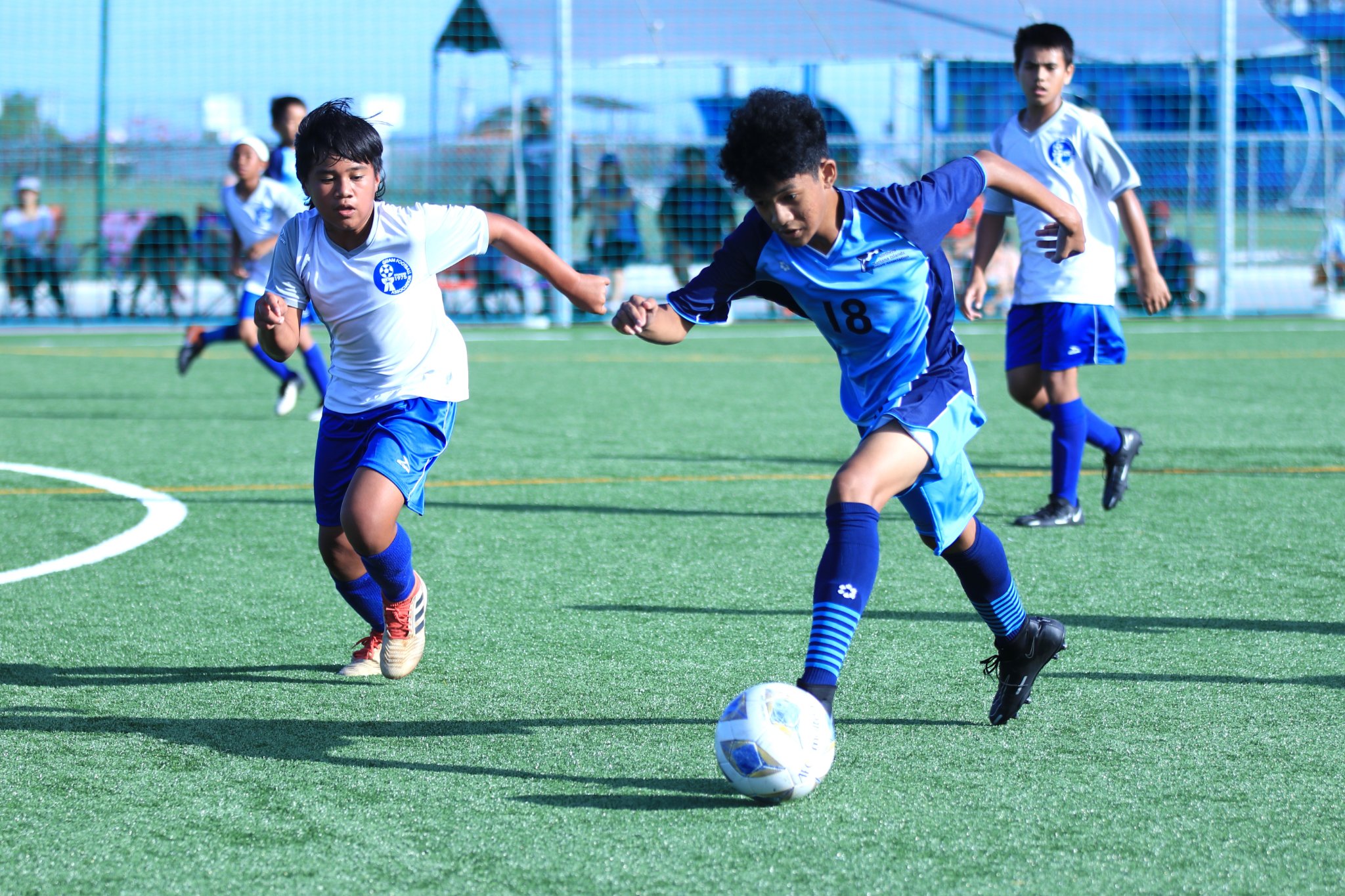The NMI U14's Emerson Brillo attempts to dribble past a Guam  defender during a friendly game at the NMI Soccer Training Center.