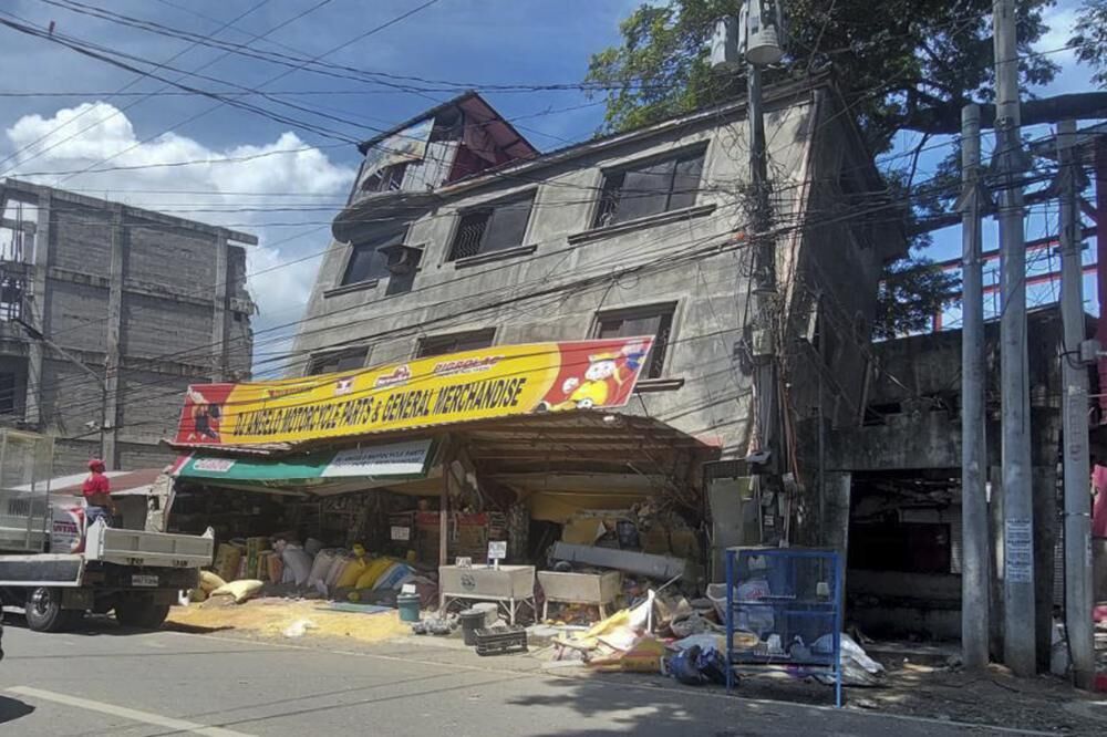 A damaged building lies on its side after a strong quake hit Bangued, Abra province, the northern Philippines on Wednesday July 27, 2022. 