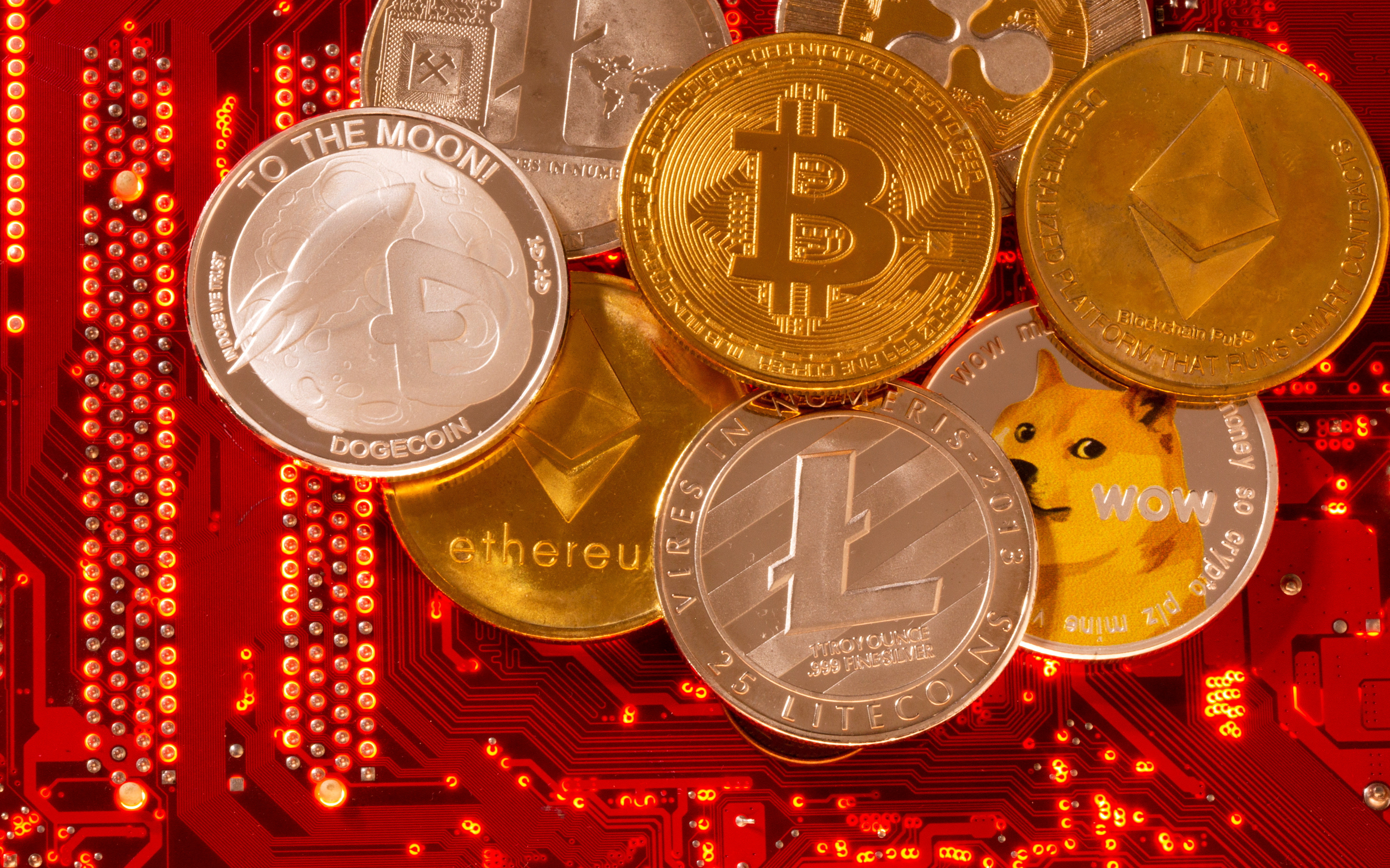 Representations of cryptocurrencies Bitcoin, Ethereum, DogeCoin, Ripple, Litecoin are placed on PC motherboard in this illustration taken on June 29, 2021.