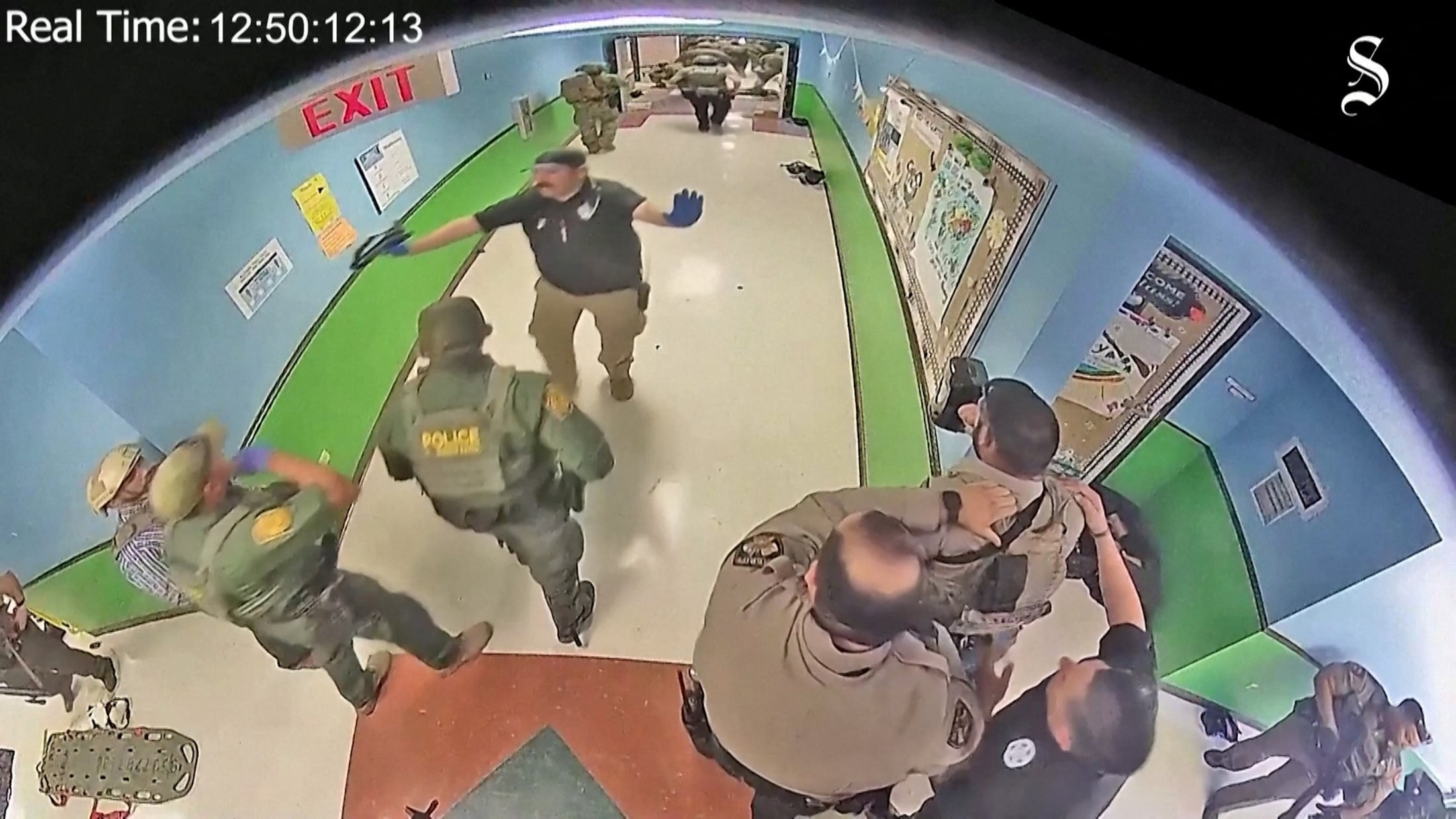 Law enforcement officers are told to stay back as shots are heard down the hall during a police entry into the Robb Elementary school classroom in which Salvador Ramos was located in Uvalde, Texas, May 24, 2022 in a still image from school surveillance video obtained by the Austin American-Statesman newspaper.