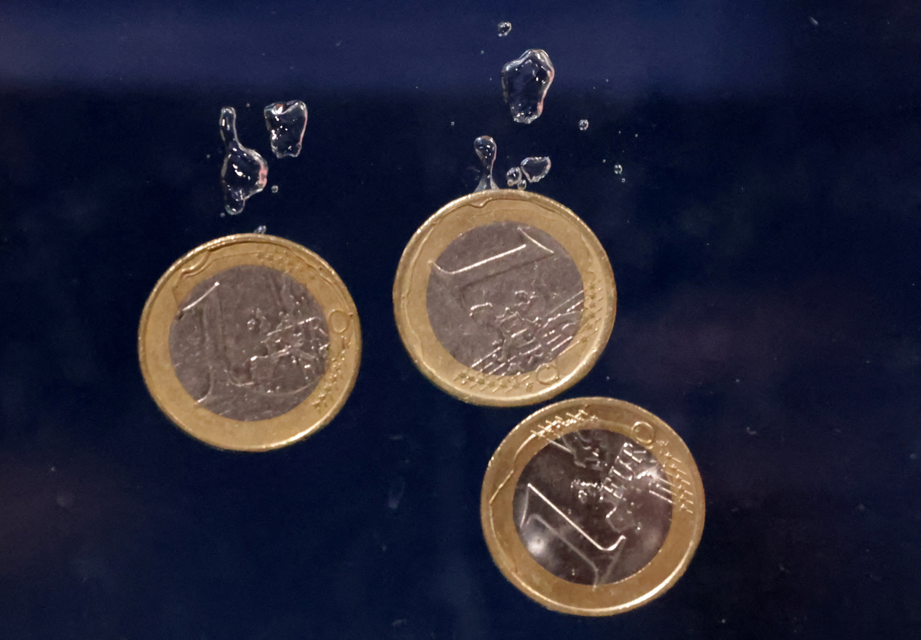 Euro coins plunge into water in this illustration taken on May 23, 2022.
