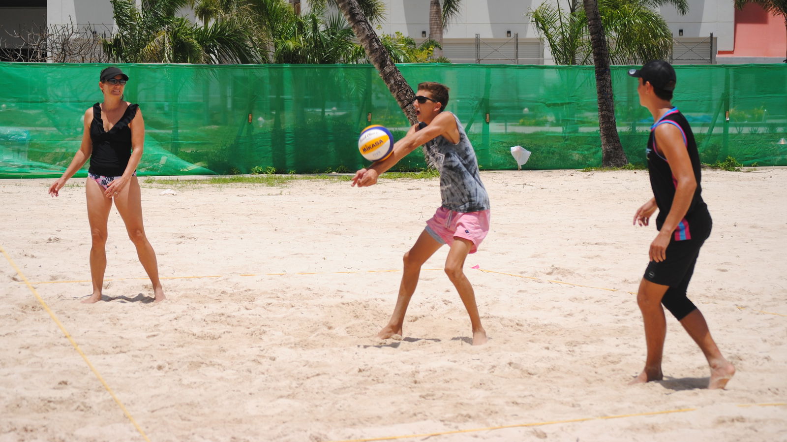 Blake Mister, center, connects the bump return as mother Angie and brother Dylan look on during a 2nd Annual Boonie Babies Rescue "Sets for Pets" Beach Volleyball Tournament game on Saturday at the Crowne Plaza beach