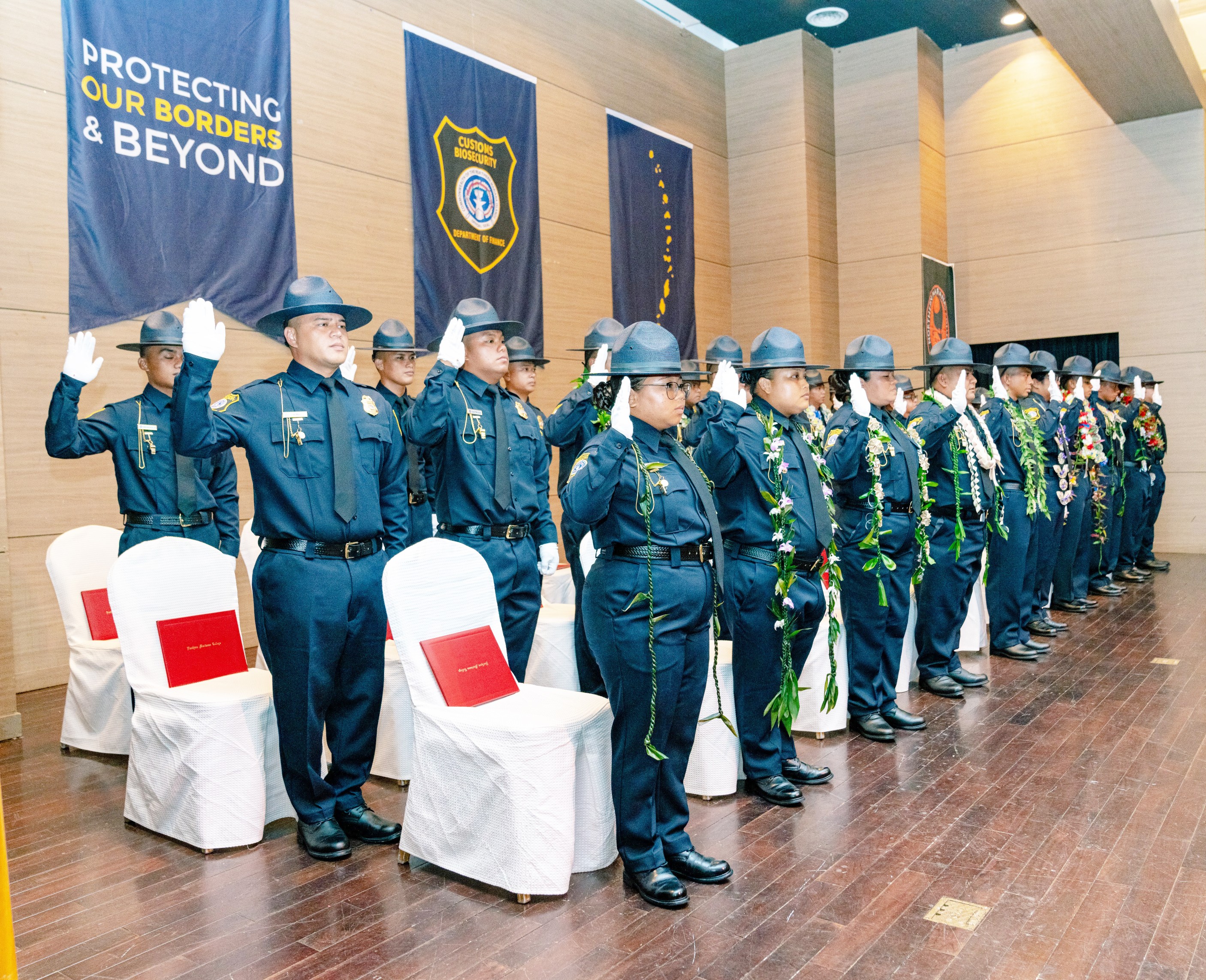 After months of rigorous training, the 29 new Division of Customs and Biosecurity officers from the 9th Cycle Academy received their badges and their Basic Law Enforcement Certificate of Completion at their graduation ceremony on Monday, July 25, 2022 at the Saipan World Resort Taga Ballroom. The academy was coordinated in partnership with Northern Marianas College. The officers received training in multiple subject areas that included Constitutional Law, Report Writing for Law Enforcement, Officer Survival Skills, Transportation and Border Security, Emergency Vehicle Operations, and Firearms Safety.